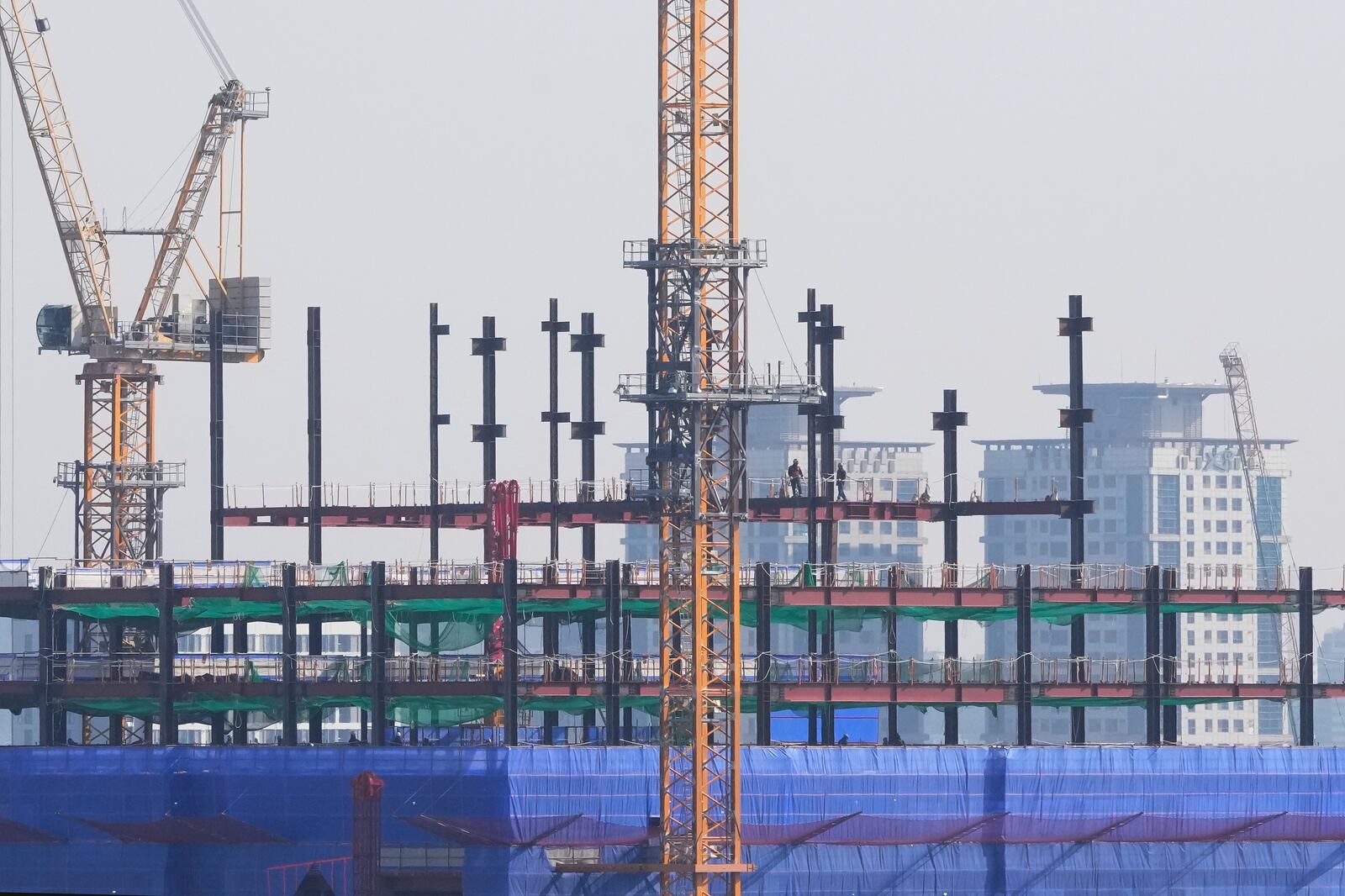 Labors work at a construction site in Seoul, South Korea, Tuesday, Feb. 11, 2025. (AP Photo/Ahn Young-joon)