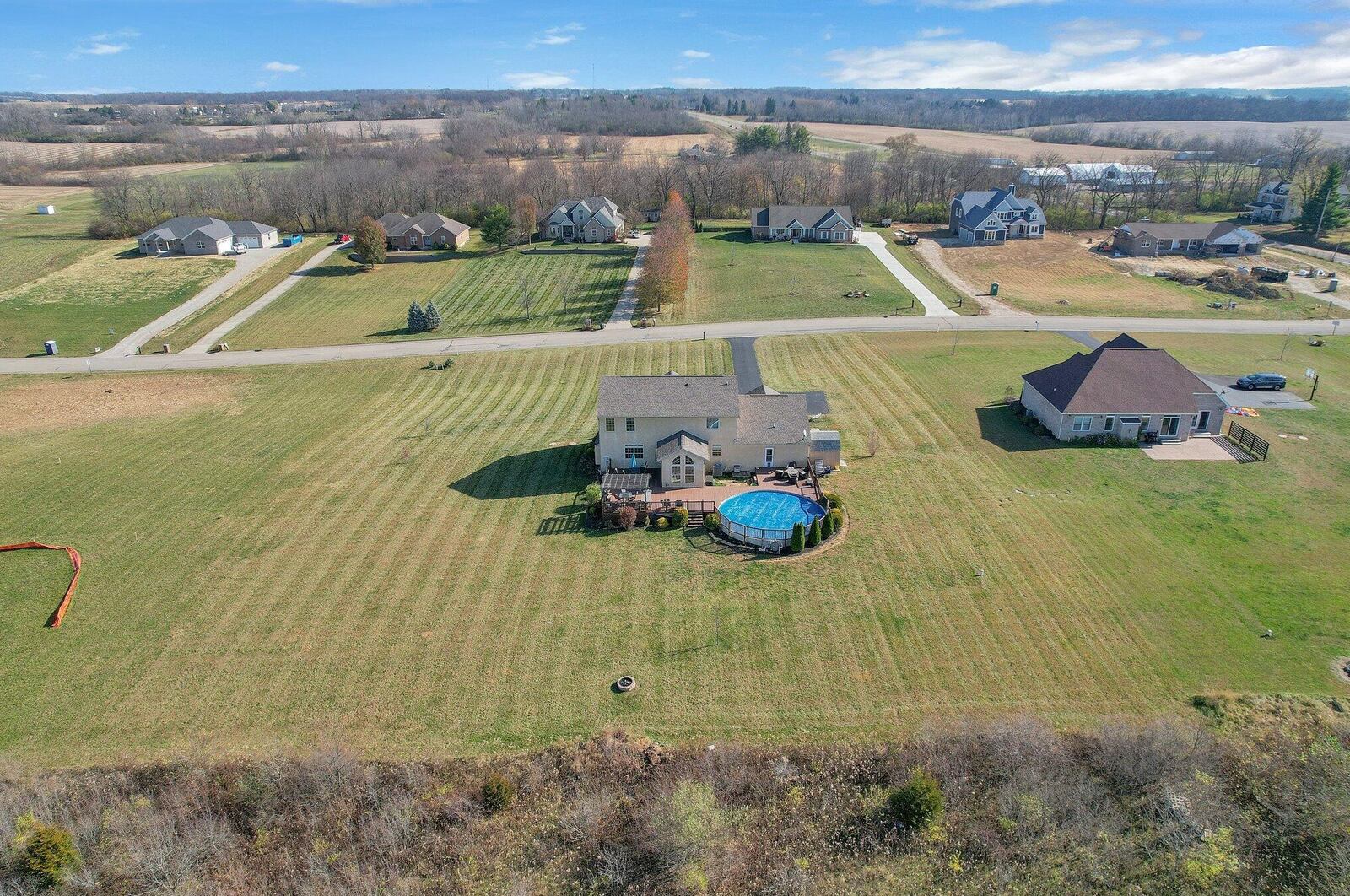 The rear of the home has a large deck with a built-in, above-ground pool and pergola. There is a brick firepit near the rear of the lot. Contributed photo 