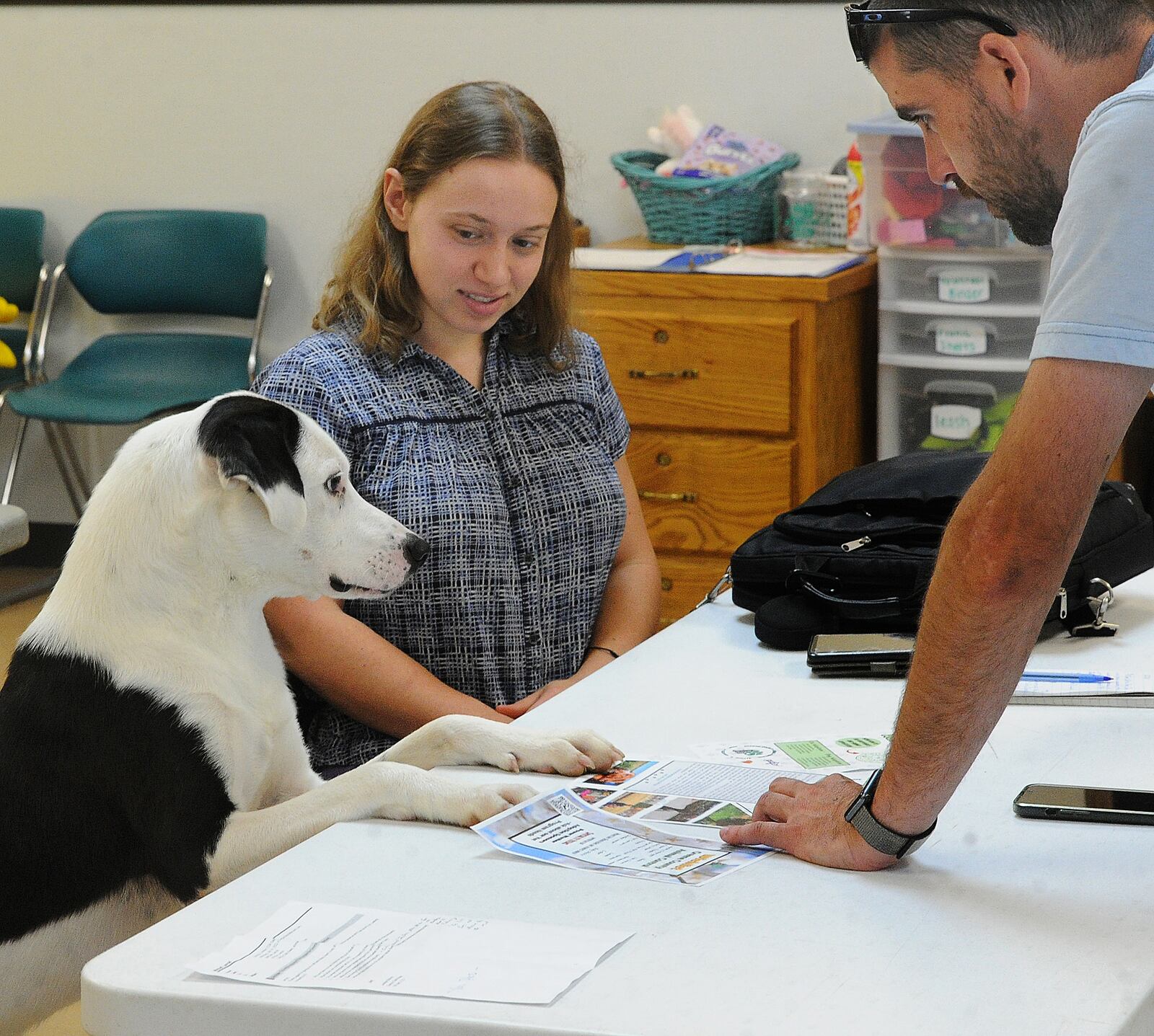 Butch (left) has important things to say to Dayton Daily News reporter London Bishop (center) and Jarrod Mitchell of Greene County Animal Control (right) about his next adoption field trip. MARSHALL GORBY\STAFF