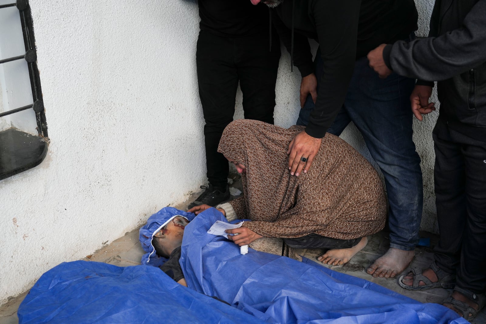 Palestinians mourn their relative who was killed in an Israeli army airstrikes, at Shifa Hospital in Gaza City, Tuesday, March 18, 2025. (AP Photo/Abdel Kareem Hana)