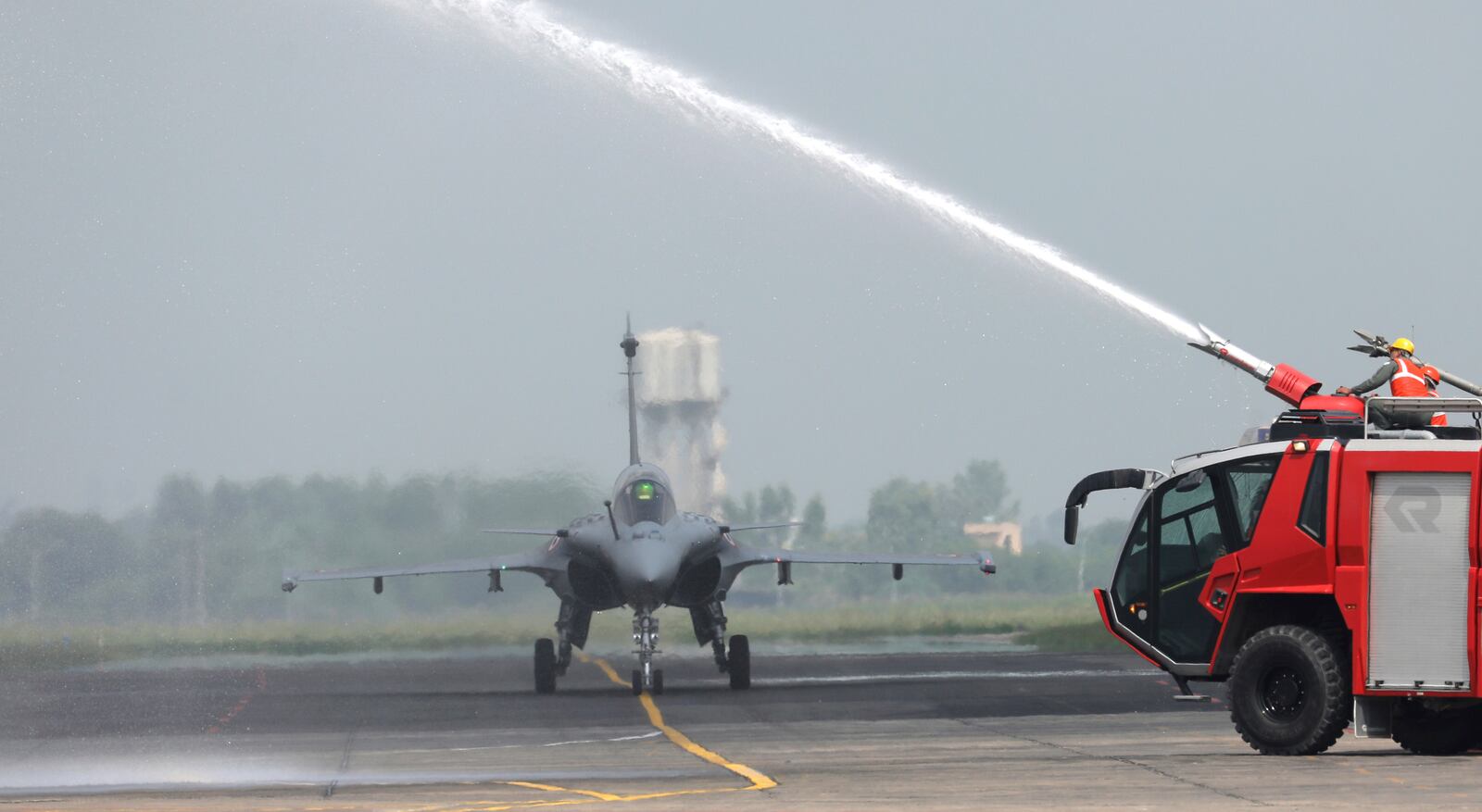 Water is sprayed on a French-made Rafale fighter jet during its induction ceremony at the Indian Air Force Station in Ambala, India, Thursday, Sept.10, 2020. The first batch of five planes, part of a $8.78 billion deal signed between the two countries in 2016 had arrived here in July. (AP Photo/Manish Swarup)