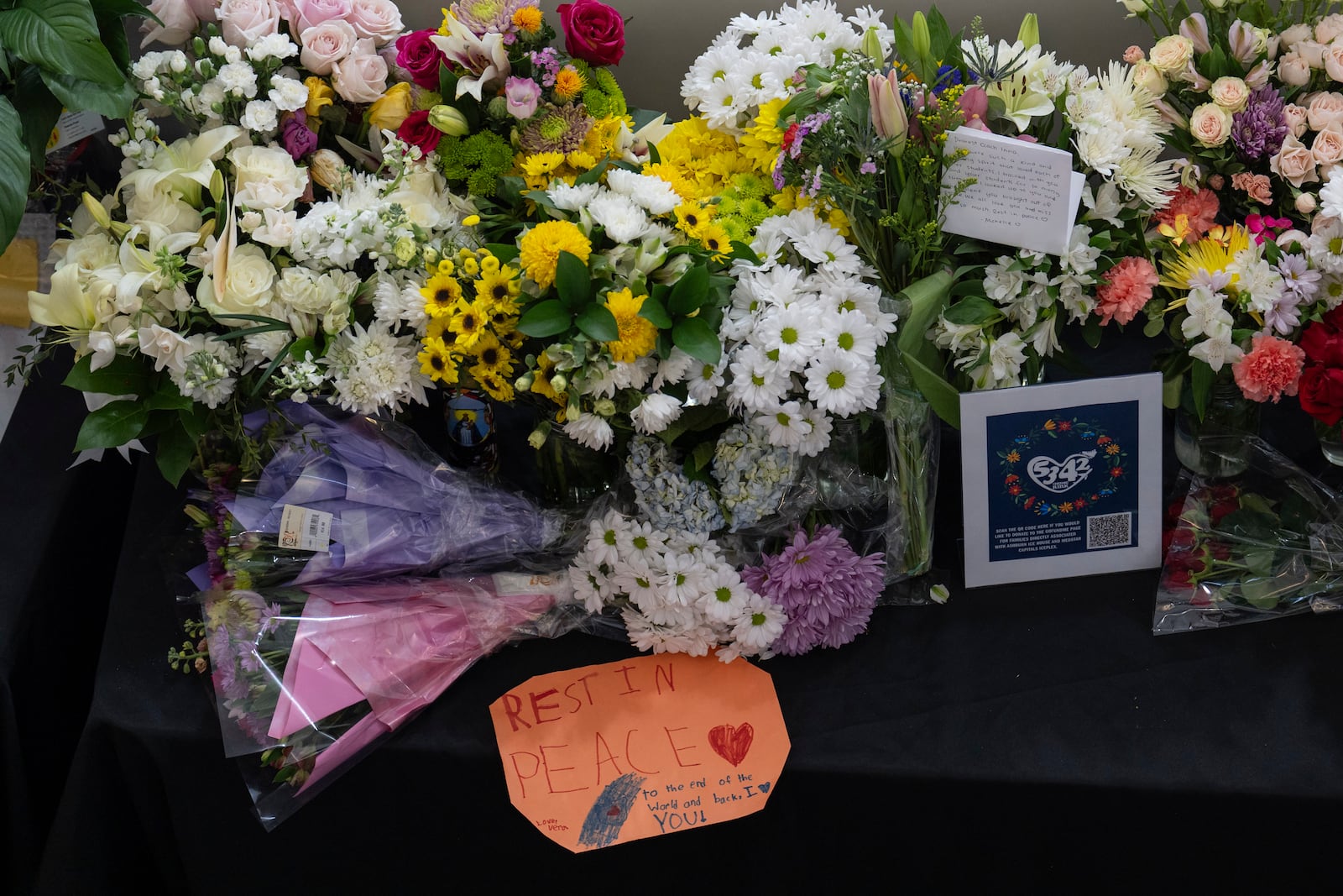 A memorial is seen along the boards at MedStar Capitals Iceplex Sunday, Feb. 2, 2025, in Arlington, Va., for the figure skaters who were among the 67 victims of a mid-air collision between an Army helicopter and an American Airlines flight from Kansas. (AP Photo/Carolyn Kaster)