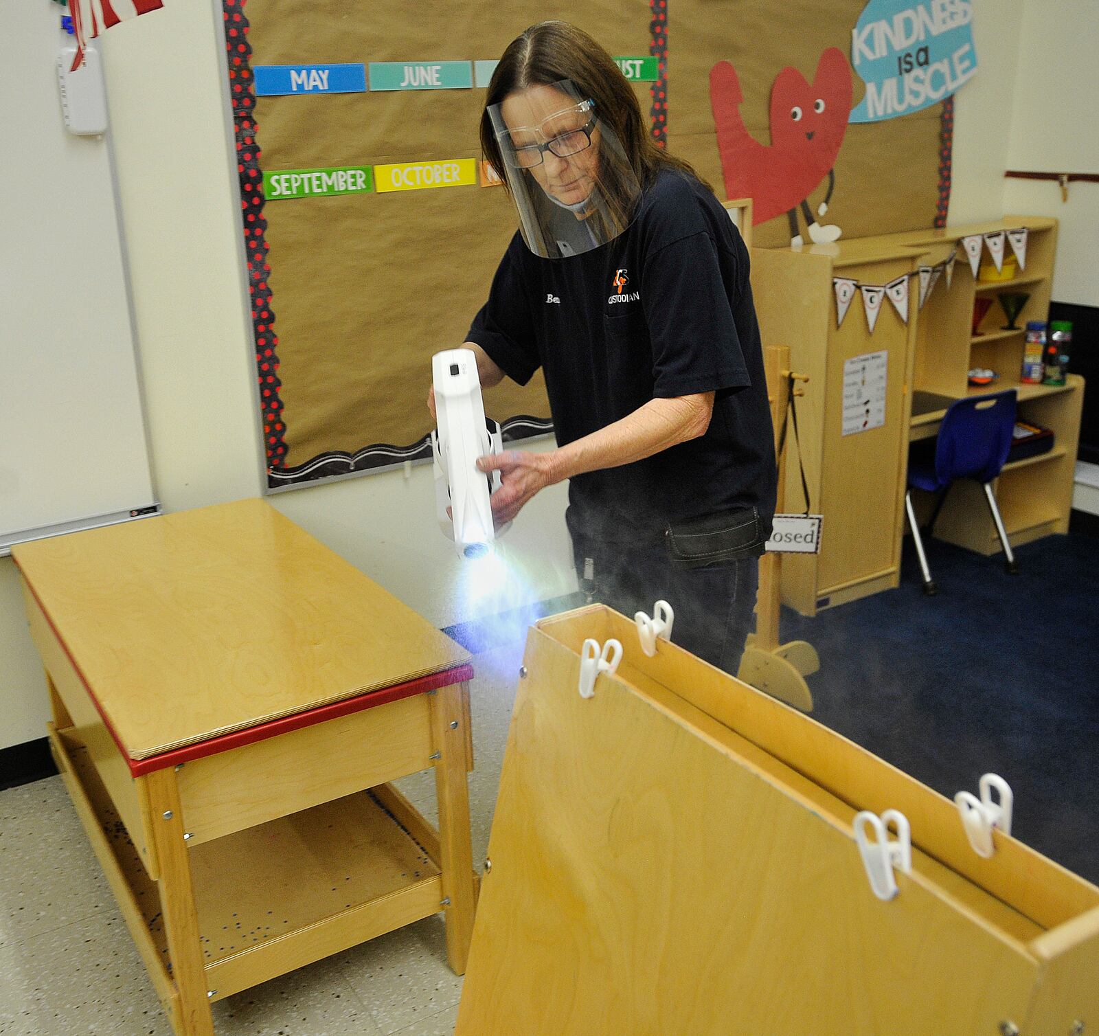 Betty Clark, a custodian for Beavercreek Schools, disinfects a pre-school classroom with a chlorination gun. Beavercreek schools have used the guns for over a year. MARSHALL GORBY\STAFF