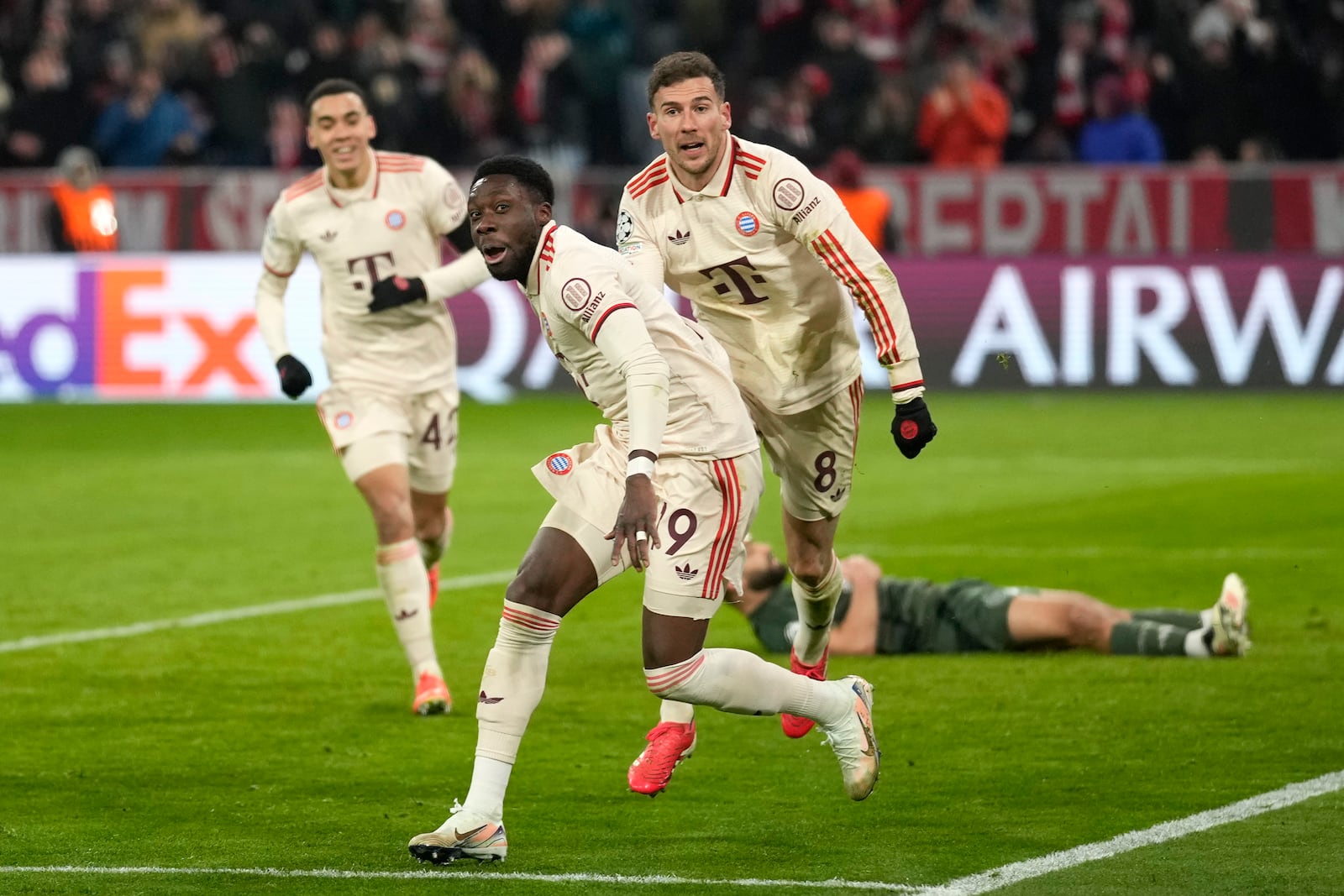 Bayern's Alphonso Davies, centre, celebrates after scoring his side's opening goal during the Champions League playoff second leg soccer match between FC Bayern Munich and Celtic Glasgow at the Allianz Arena in Munich, Germany, Tuesday, Feb. 18, 2025. (AP Photo/Matthias Schrader)