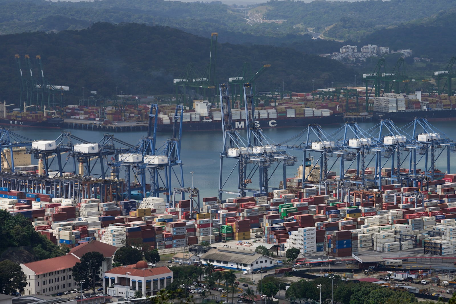 Cargo containers sit stacked as cranes load and unload containers from cargo ships at the Panama Canal's Balboa port, operated by the Panama Ports Company, in Panama City, Friday, Jan. 31, 2025. (AP Photo/Matias Delacroix)