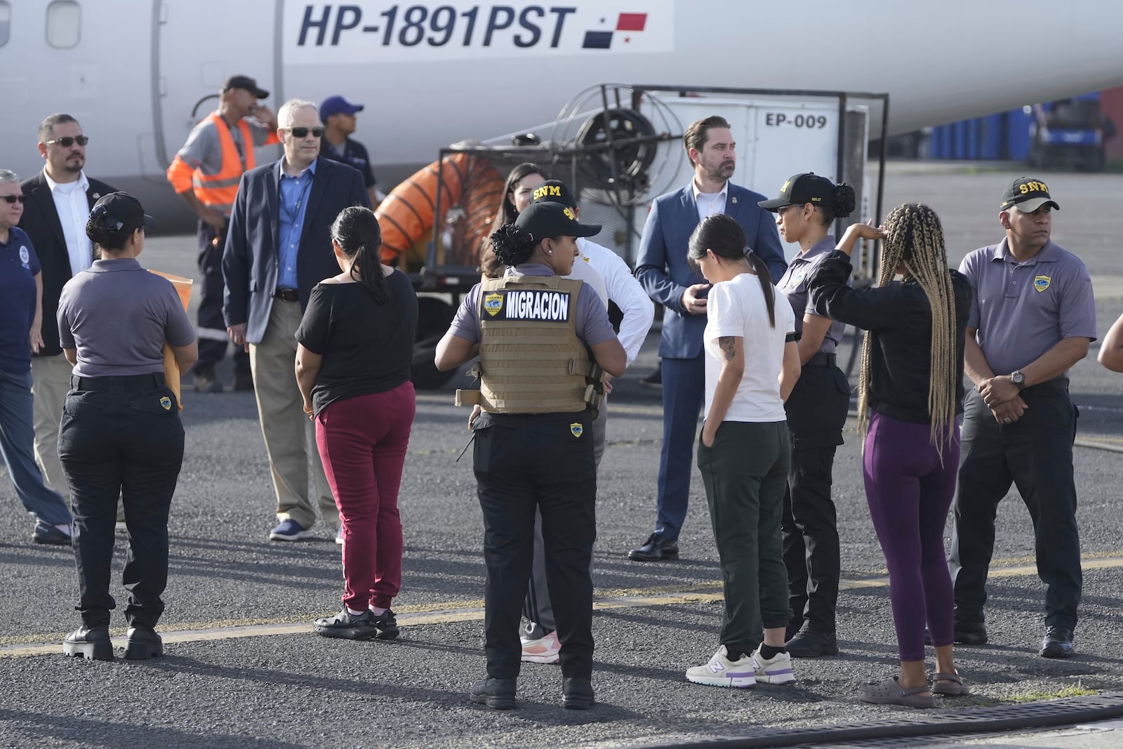 People line up to board a repatriation flight bound for Colombia at Albrook Airport in Panama City, Monday, Feb. 3, 2025. (AP Photo/Mark Schiefelbein, Pool)