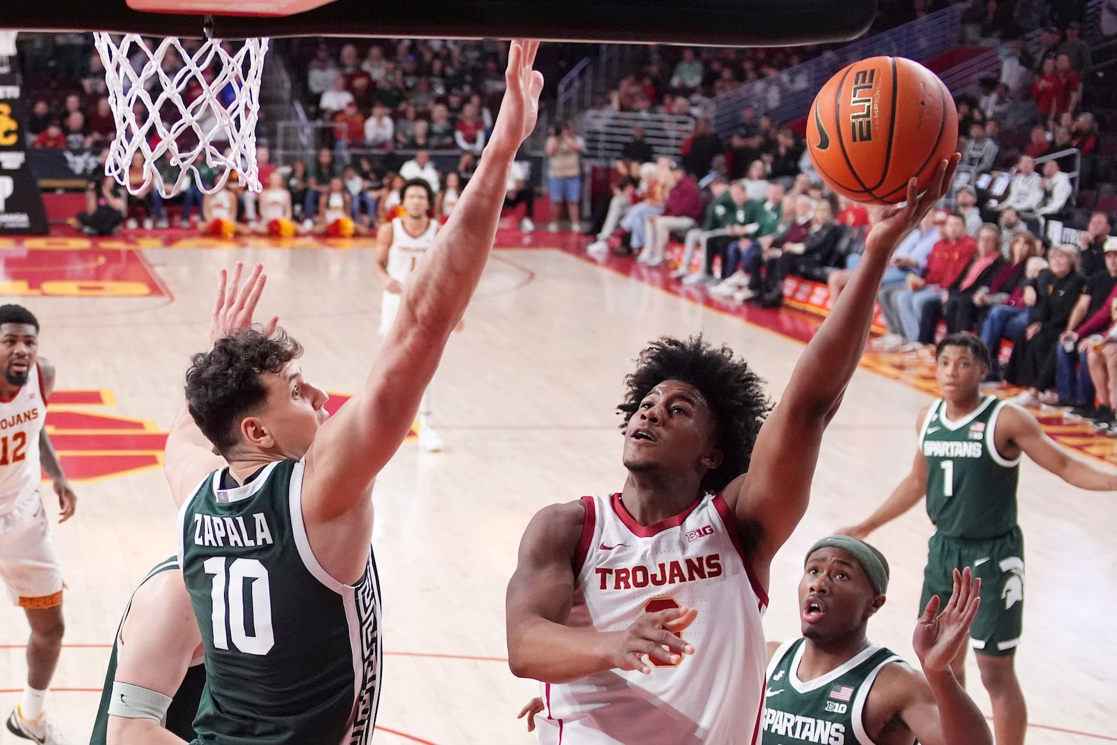 Southern California guard Wesley Yates III, right, shoots as Michigan State center Szymon Zapala defends during the first half of an NCAA college basketball game, Saturday, Feb. 1, 2025, in Los Angeles. (AP Photo/Mark J. Terrill)