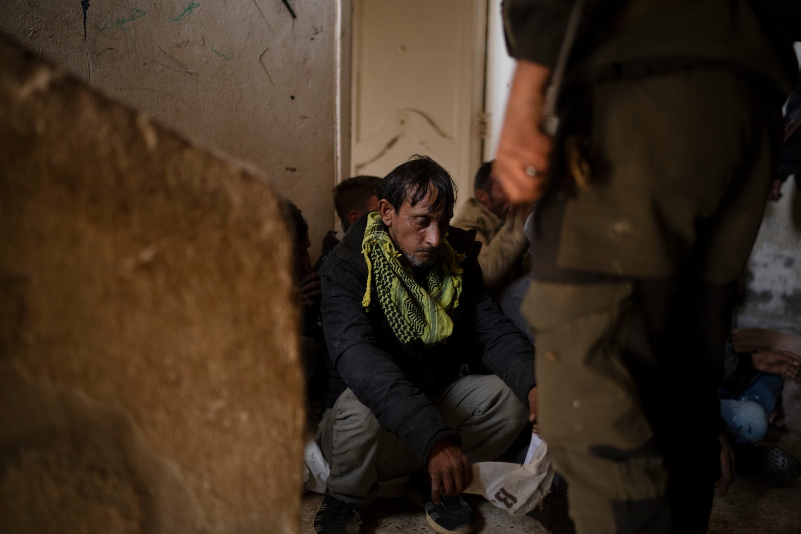 Syrian fighters detain men suspect of looting at a residential complex of former Bashar Assad's military officers at the village of Husseiniyeh, in the outskirts of Damascus, Syria, Sunday, Dec. 15, 2024. (AP Photo/Leo Correa)