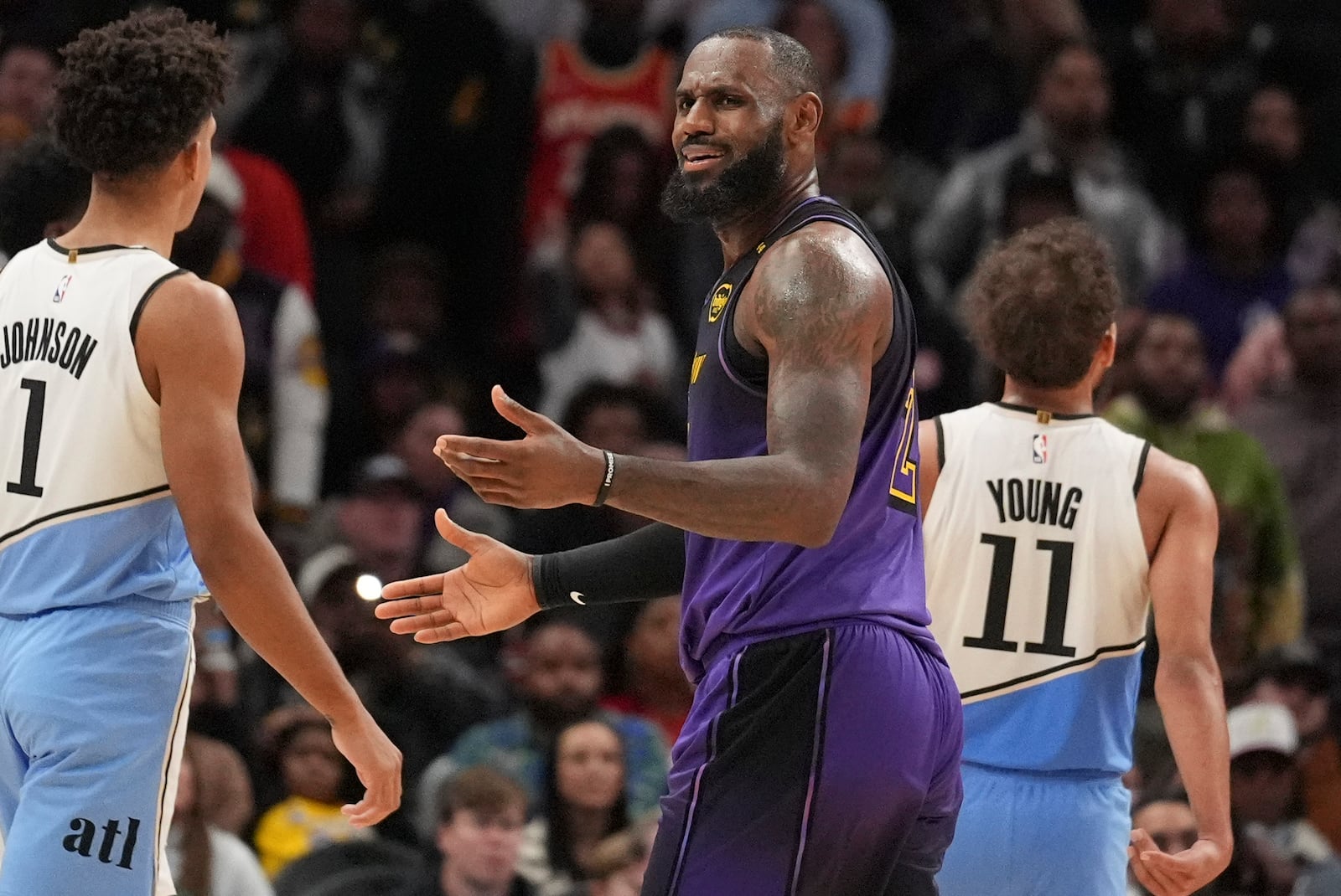 Los Angeles Lakers forward LeBron James (23) reacts to a foul against Atlanta Hawks guard Trae Young (11) in the second half of an NBA basketball game, Friday, Dec. 6, 2024, in Atlanta. (AP Photo/Brynn Anderson)