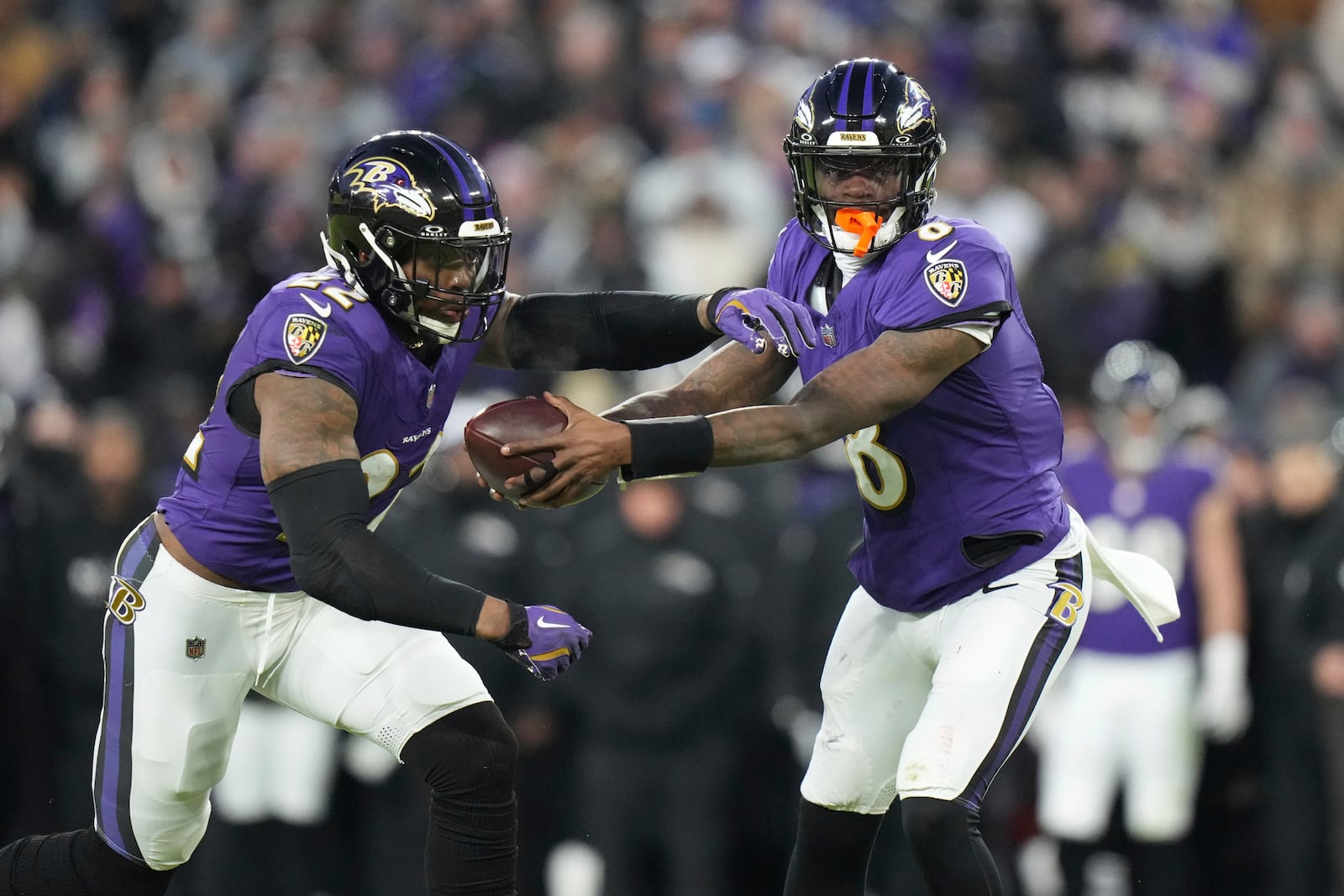 Baltimore Ravens quarterback Lamar Jackson, right, fakes a hand off to running back Derrick Henry during the first half of an NFL football game against the Cleveland Browns Saturday, Jan. 4, 2025, in Baltimore. (AP Photo/Stephanie Scarbrough)