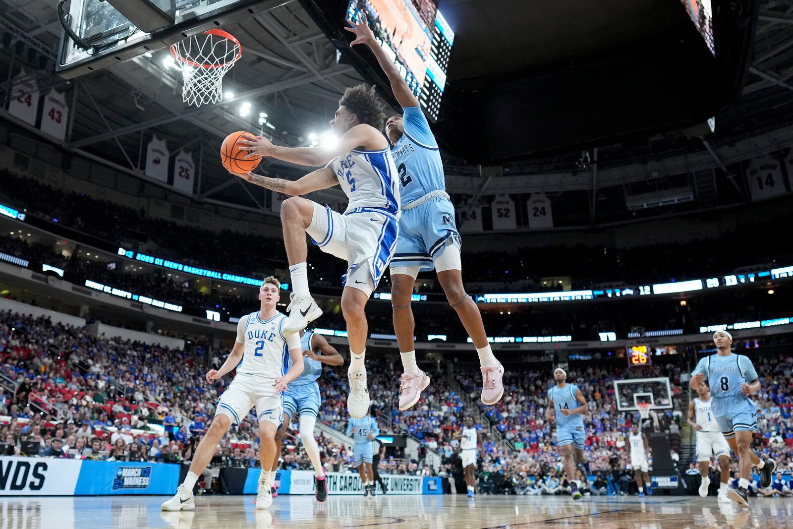 Duke guard Tyrese Proctor drives to the basket past Mount St. Mary's guard Arlandus Keyes during the first half in the first round of the NCAA college basketball tournament, Friday, March 21, 2025, in Raleigh, N.C. (AP Photo/Chris Carlson)