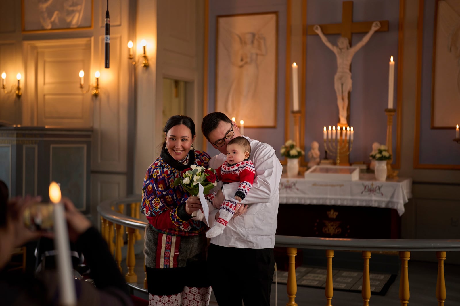 Salik Schmidt and Malu Schmidt hold their 8-month daughter as they pose for a photo during their wedding at the Church of our Savior in Nuuk, Greenland, Saturday, Feb. 15, 2025. (AP Photo/Emilio Morenatti)