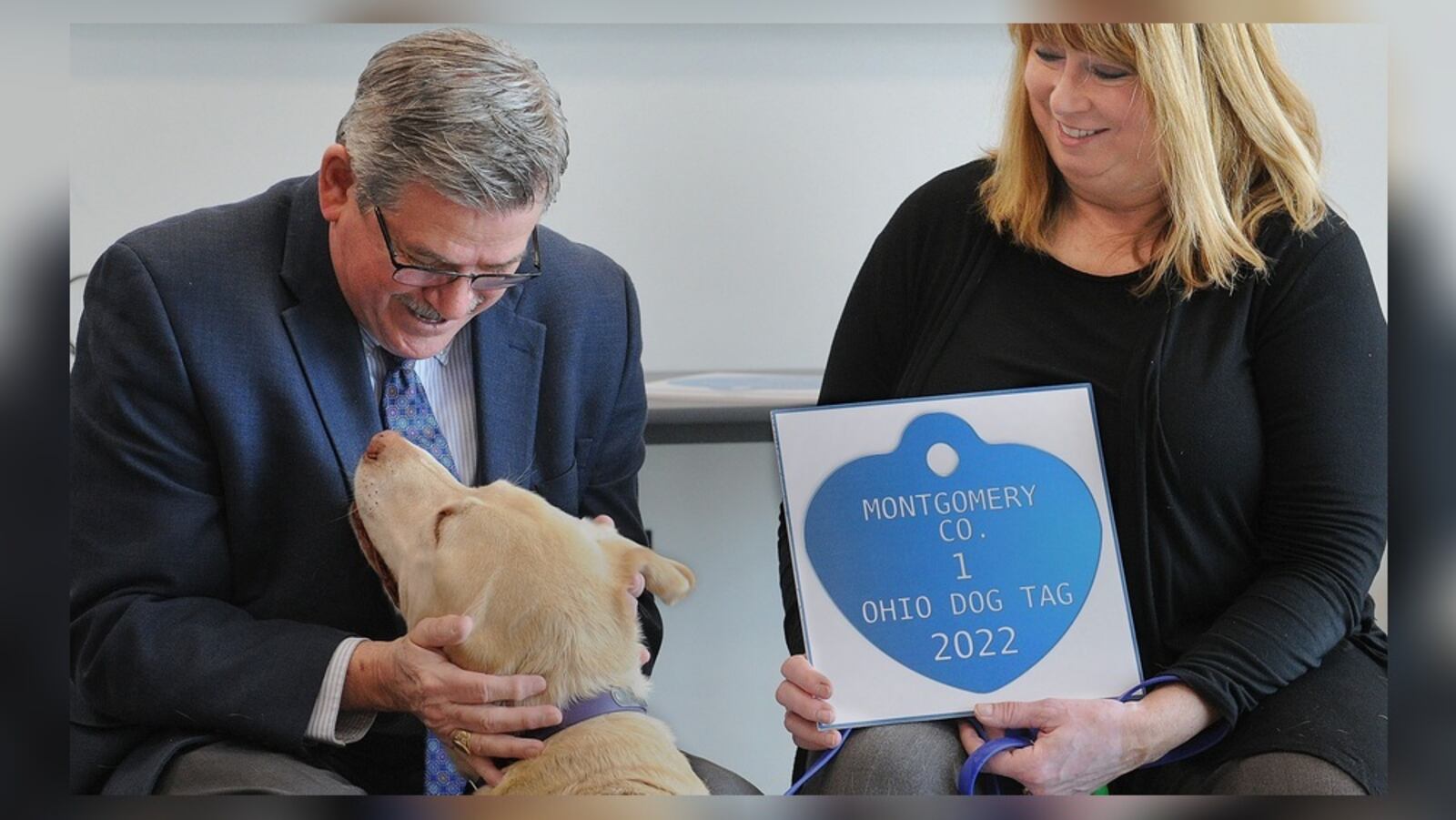 Montgomery County Auditor Karl Keith, left, congratulates Manchu and his owner Elaine Allison for receiving the Montgomery County 1 Ohio Dog Tag for 2022. The ceremony held Wednesday, Jan. 19, 2022, at the SICSA Pet Adoption and Wellness Center in Washington Twp. recognizes the top three dogs of the year in the county. MARSHALL GORBY\STAFF