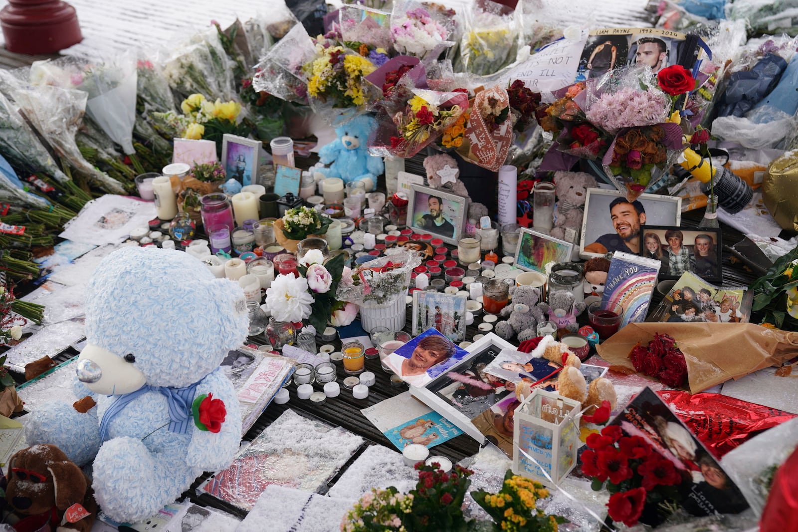 Flowers, portraits and toys lay in the ground for memory of the One Direction star singer Liam Payne at a memorial in West Park in his hometown of Wolverhampton, England, Wednesday, Nov. 20, 2024. (Jacob King/PA via AP)