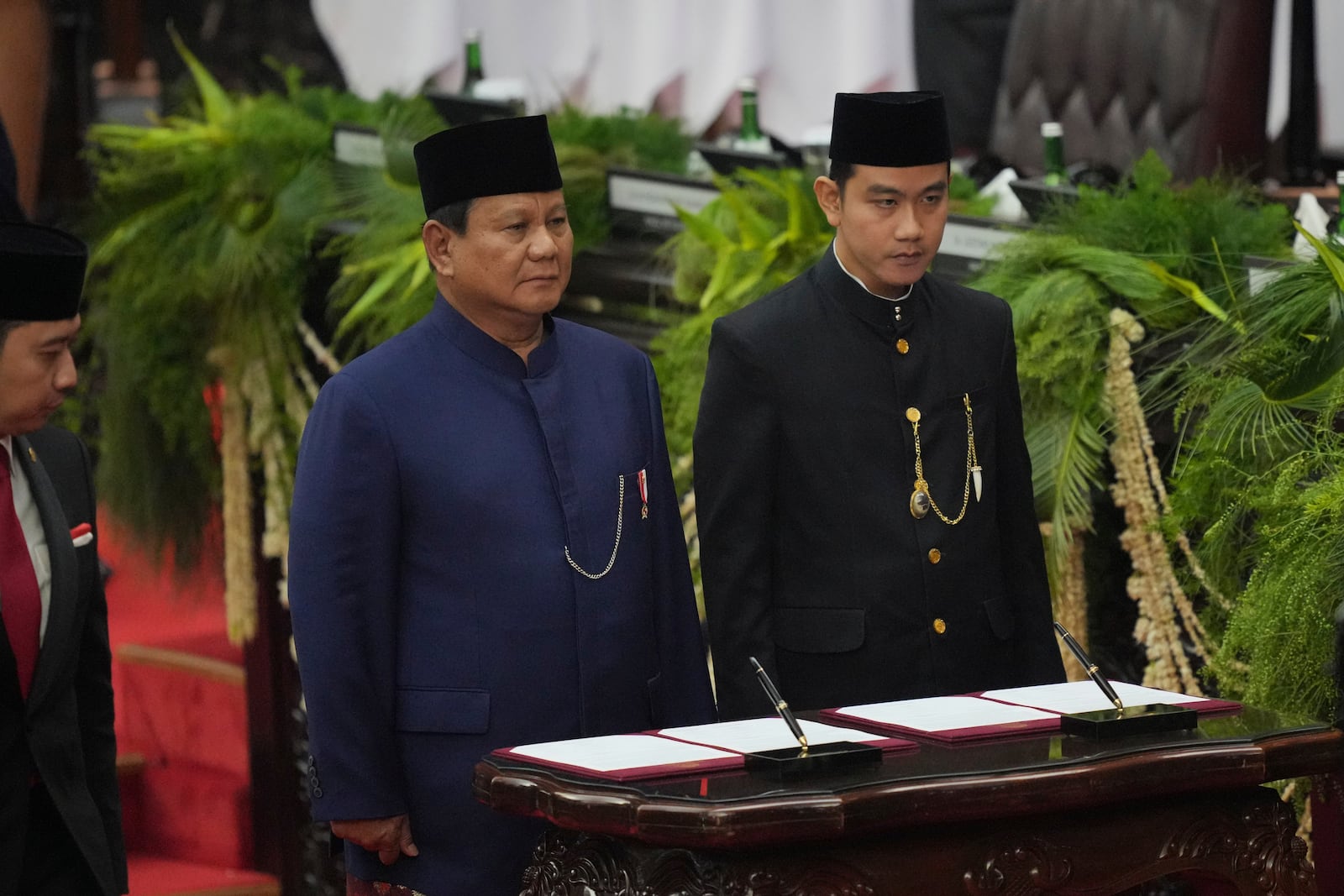 Indonesia's newly-inaugurated President Prabowo Subianto, left, and Vice President Gibran Rakabuming Raka prepare to sign their inauguration documents during their swearing in ceremony at the parliament building in Jakarta, Indonesia, Sunday, Oct. 20, 2024. (AP Photo/Tatan Syuflana)