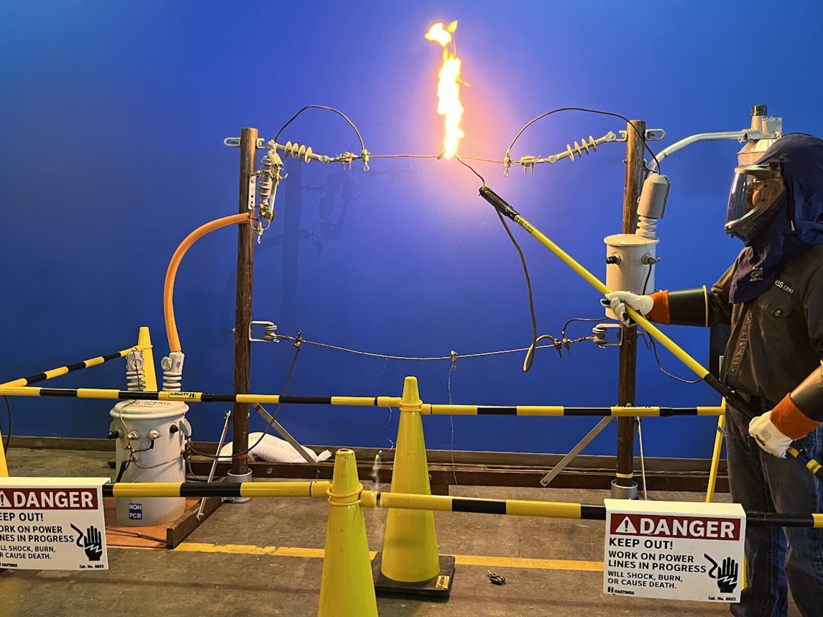 AES Ohio technician A. J. Montgomery touches a live wire with a "hot stick," setting off a flame. THOMAS GNAU/STAFF