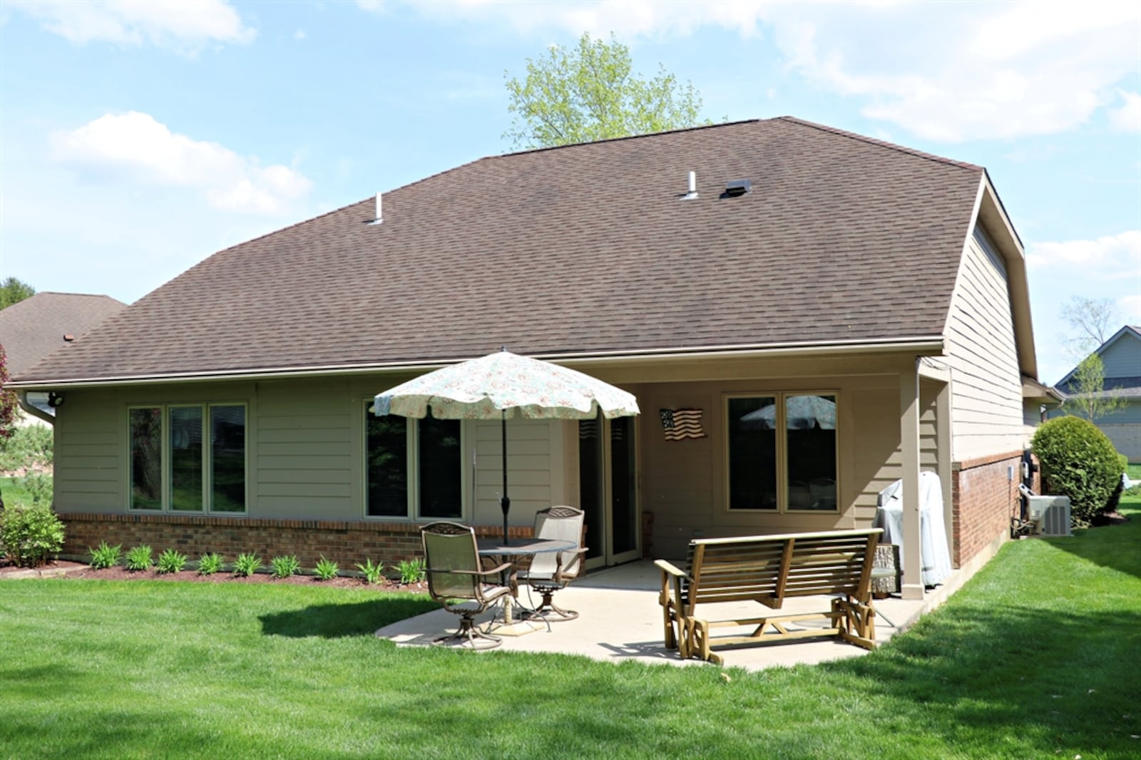 Mature trees line the backyard and a landscaped creek is accented by spring flowers.