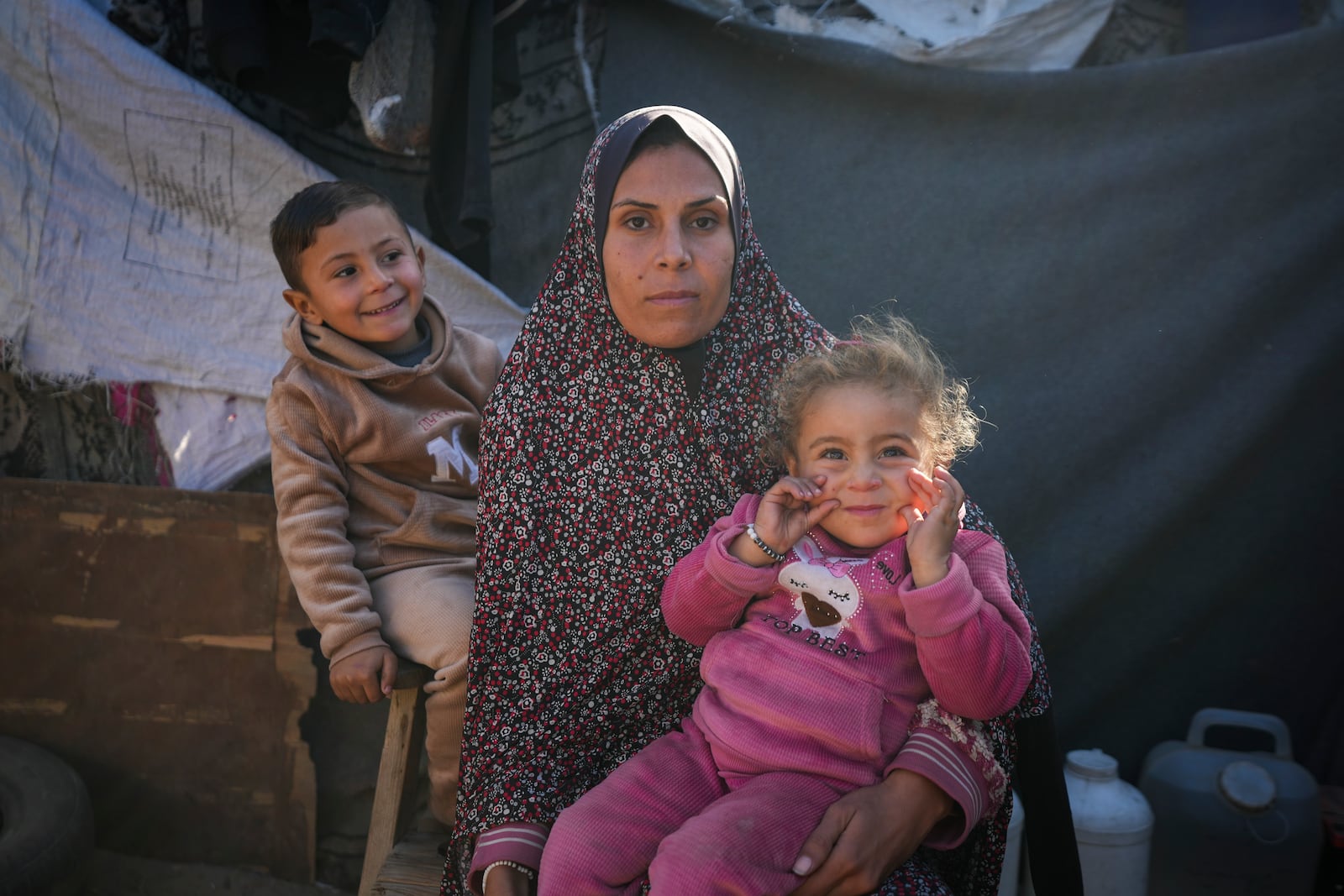 Wafaa Nasrallah poses for a portrait with her 4-year-old son Ameer and her 2-year-old daughter Ayloul at her tent at a camp for displaced Palestinians in Deir al-Balah, Gaza Strip, Dec. 28, 2024. (AP Photo/Abdel Kareem Hana)