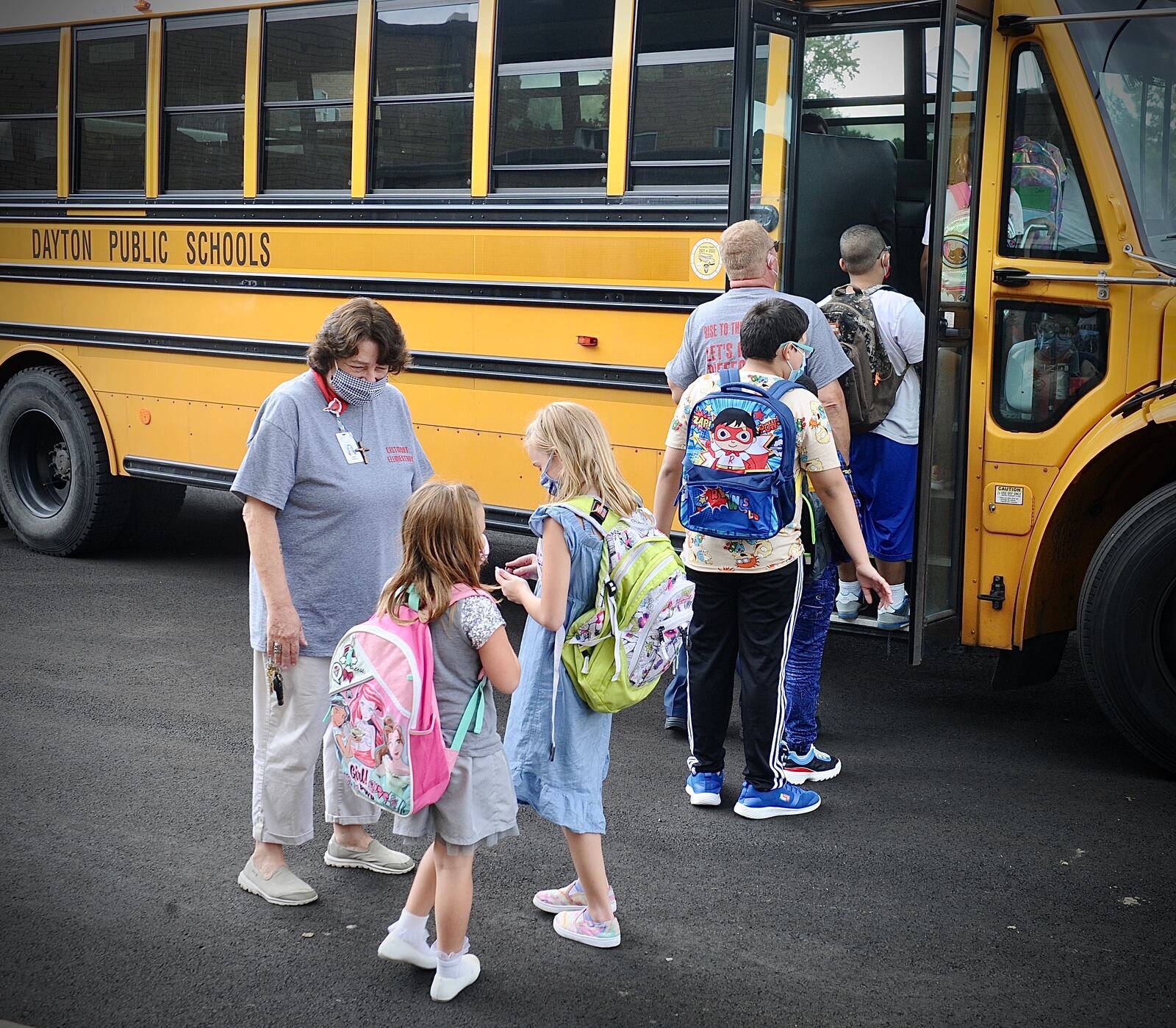 Students at Eastmont elementary in Dayton wait to board the bus at the end of the first day of school on Wednesday Aug. 18, 2021. MARSHALL GORBY\STAFF