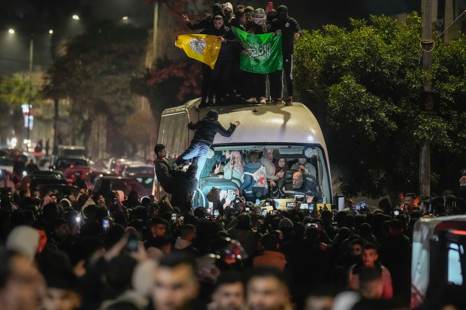 A crowd gathers around a bus carrying released Palestinian prisoners as it arrives in the West Bank city of Beitunia, early Monday, Jan. 20, 2025. (AP Photo/Leo Correa)