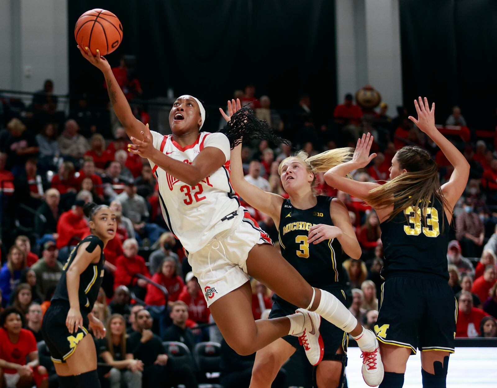 Ohio State forward Cotie McMahon, left, shoots in front of Michigan guard Maddie Nolan, center, and forward Emily Kiser during the second half of an NCAA college basketball game in Columbus, Ohio, Saturday, Dec. 31, 2022. Ohio State won 66-57. (AP Photo/Paul Vernon)