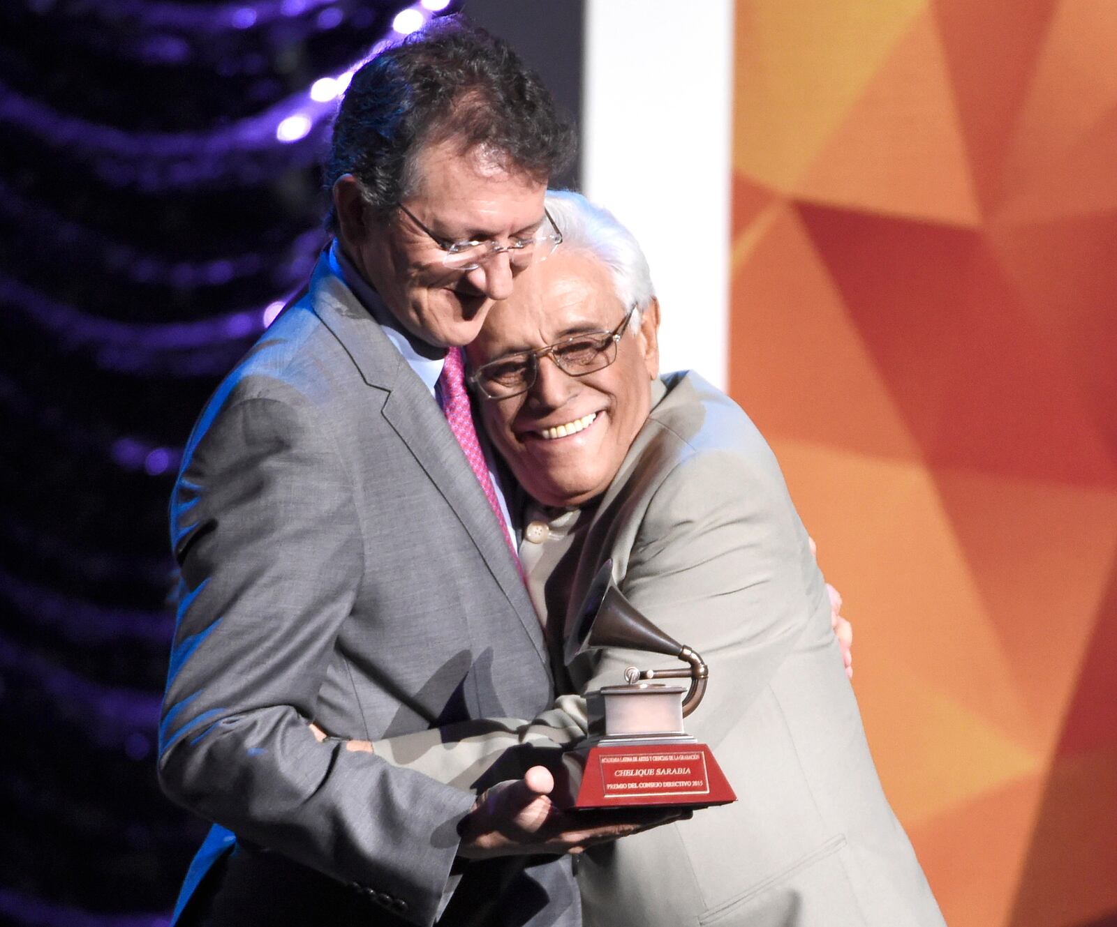 FILE - Gabriel Abaroa Jr., president and CEO of the Latin Recording Academy, left, presents a Trustees Award to Venezuelan poet and musician Chelique Sarabia, at the Lifetime Achievement and Trustees Awards program, in Las Vegas, Nov. 18, 2015. (Photo by Chris Pizzello/Invision/AP File)