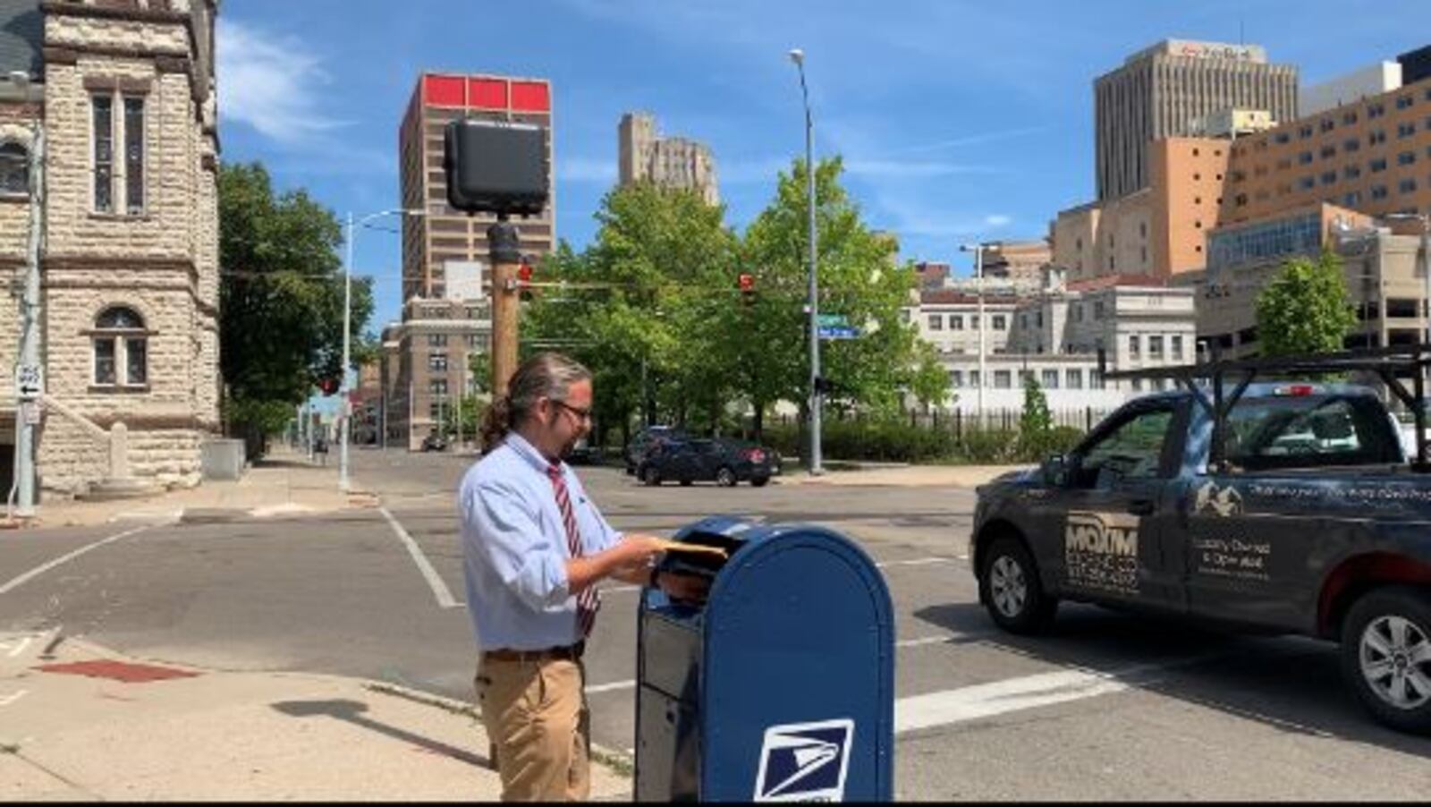 Dayton Daily News reporter Josh Sweigart deposits envelopes roughly the same size and weight of ballots into a mailbox in downtown Dayton as part of a test of the U.S. Postal Service.