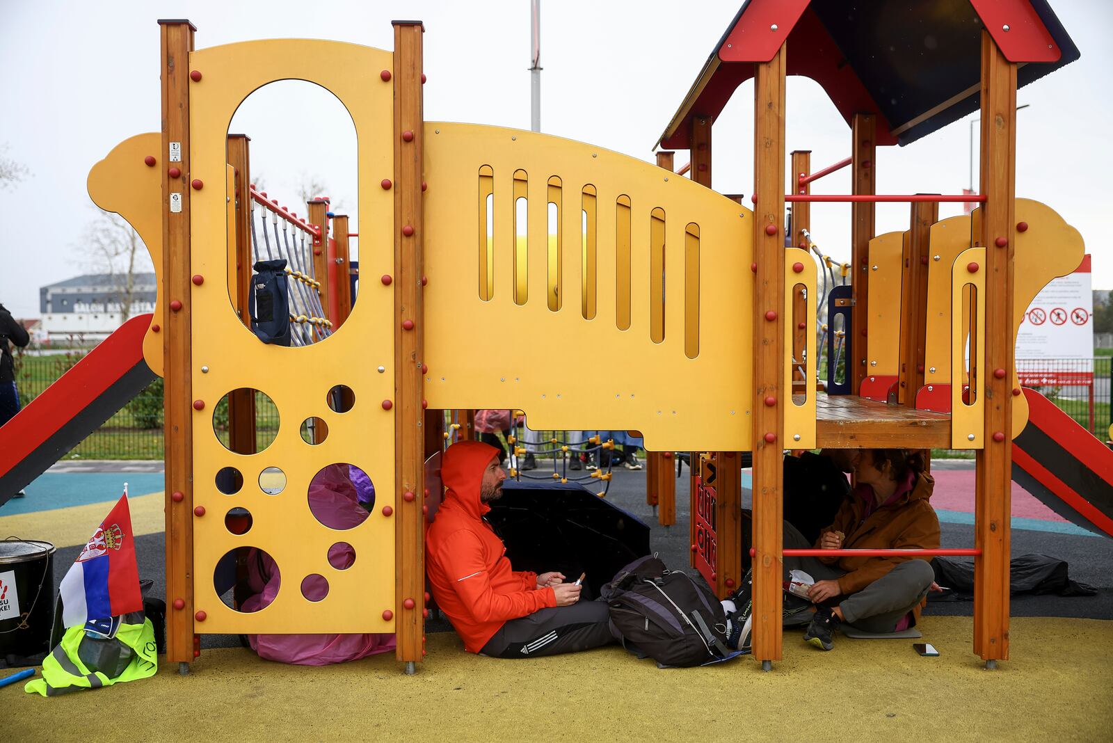 Students, who are on a march to Belgrade for a joint protest, shelter from the rain at a children's playground, in Nova Pazova, Serbia, Friday, March 14, 2025. (AP Photo/Armin Durgut)