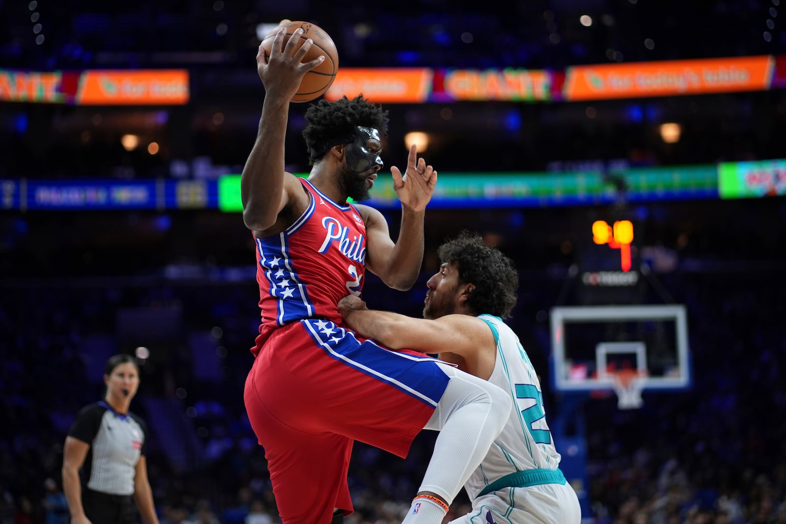 Philadelphia 76ers' Joel Embiid left, tries to go up for a shot against Charlotte Hornets' Vasilije Micic during the second half of an NBA basketball game, Friday, Dec. 20, 2024, in Philadelphia. (AP Photo/Matt Slocum)