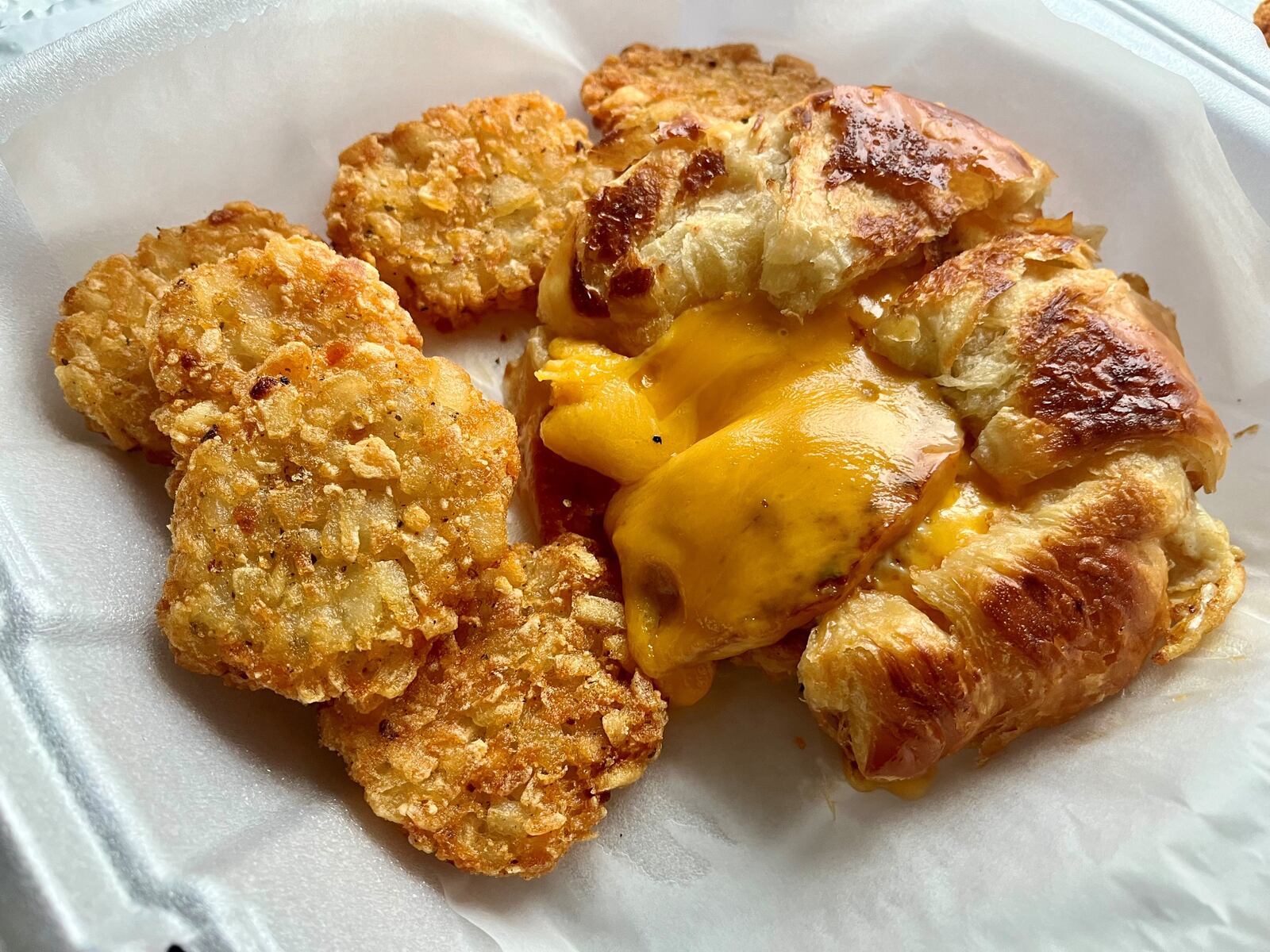 A ham, egg and cheese croissant with potato cakes from Cherry House Cafe. NATALIE JONES/STAFF