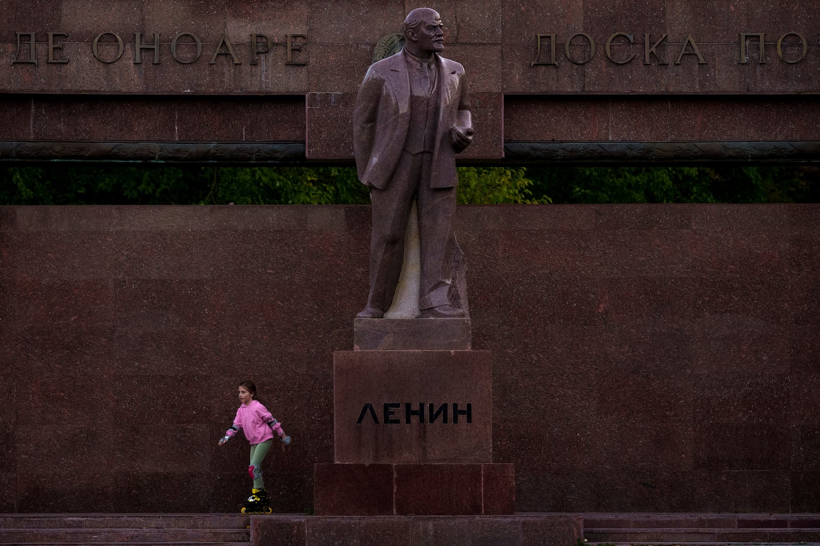 FILE - A girl skates next to a statue of Lenin, with the words "Board of Honor" written in Cyrillic in Romanian and Russian in Chisinau, Moldova, Friday, Nov. 1, 2024. (AP Photo/Vadim Ghirda, File)