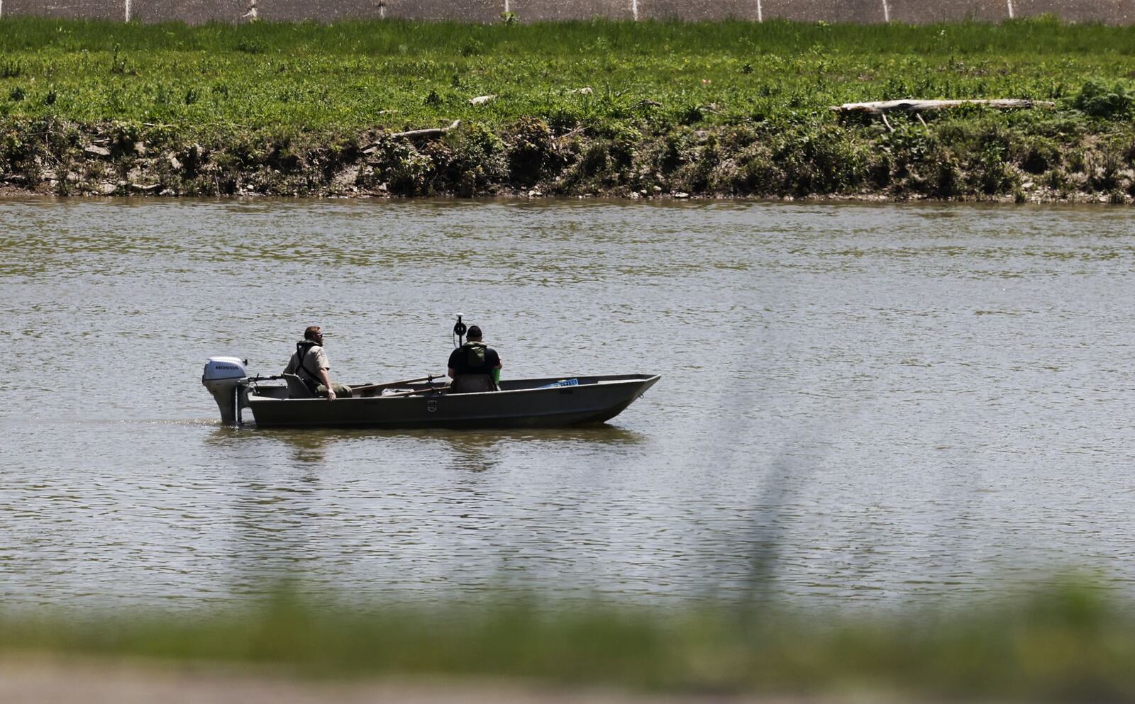 Law enforcement agencies and volunteers search the Great Miami River Tuesday, May 9, 2022 for a person who fled into the river. Butler County Sheriff's Office crews are searching by boat and a group from North Star Seach and Rescue has canines out searching along the river banks. NICK GRAHAM/STAFF