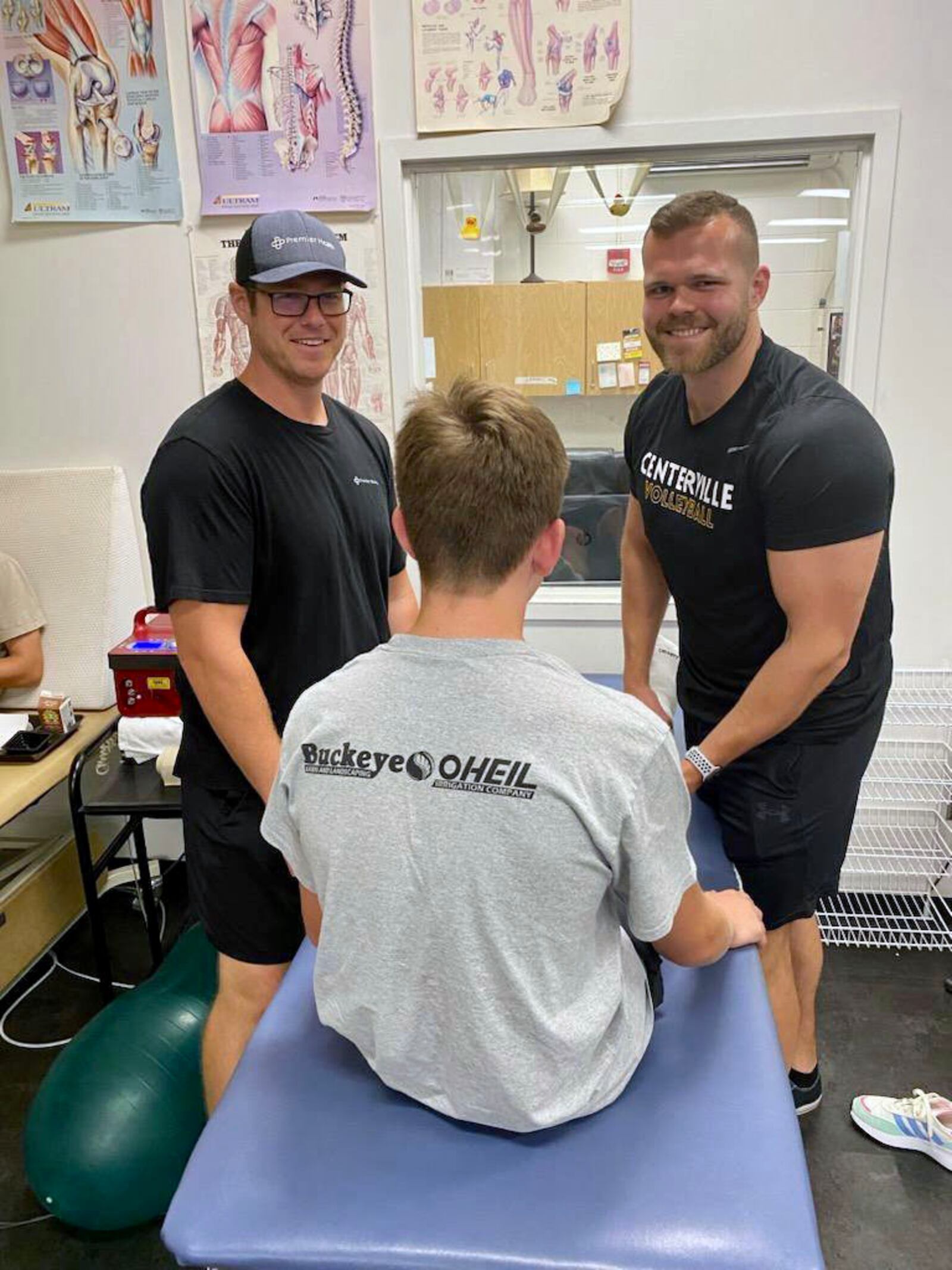 Centerville athletic trainers Brandon Craig, left and Karl Knutsson, right work with a student at Centerville High School Tuesday. Courtesy of Centerville Schools.