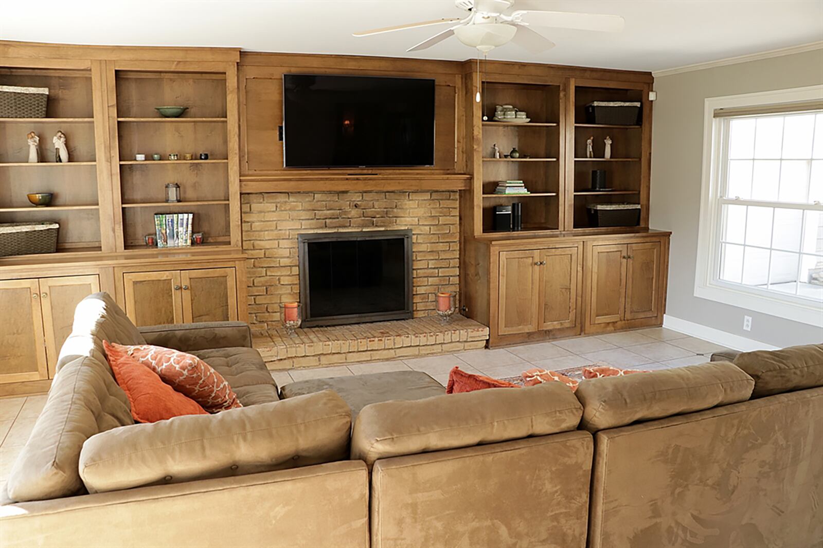 Double pocket doors open from the dining room into a family room with two picture windows, patio doors that open out to a rear side paver-brick patio and a single door that opens out to the driveway. One whole wall has built-in cabinetry that surrounds a brick fireplace with raised hearth. CONTRIBUTED PHOTO BY KATHY TYLER