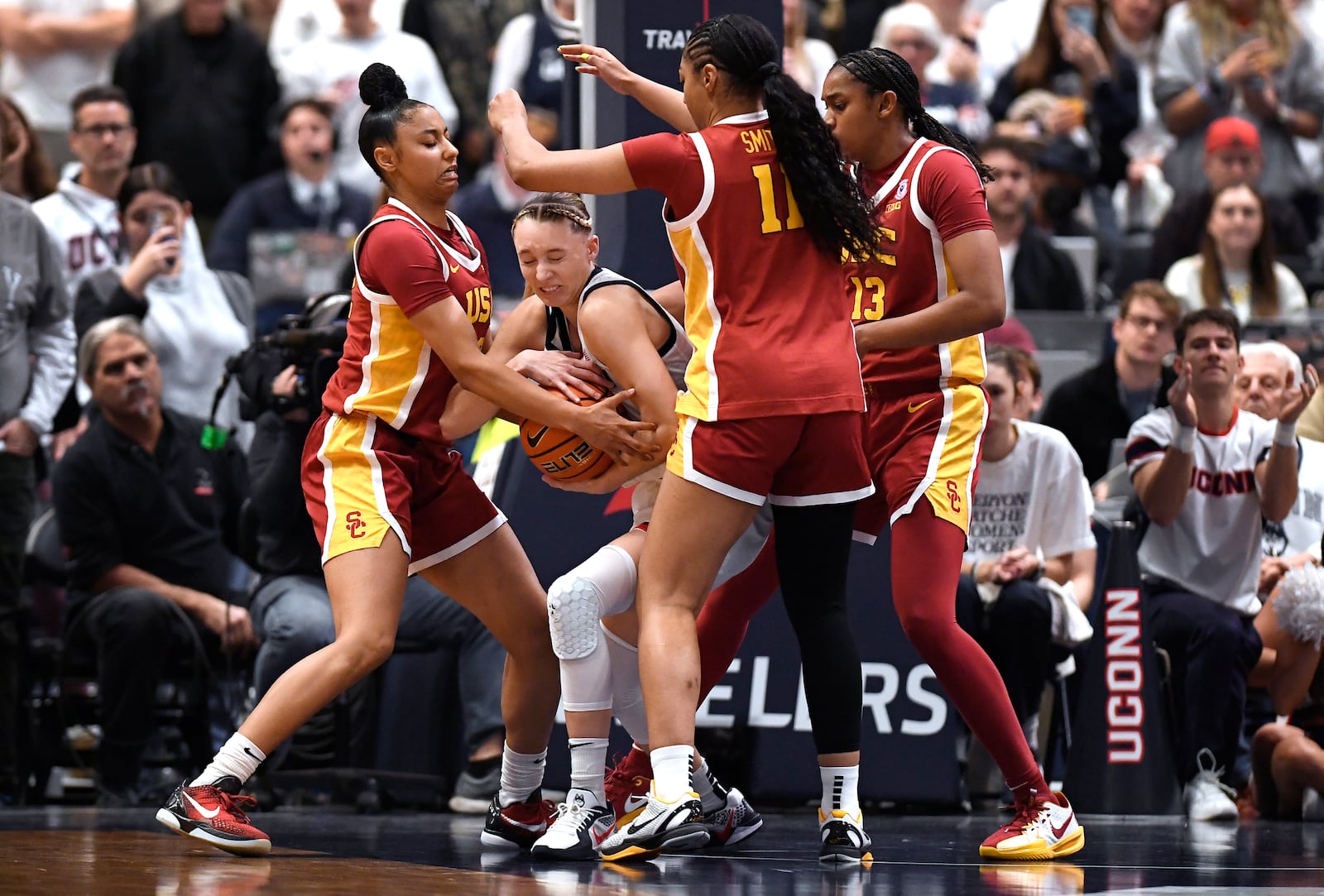 UConn guard Paige Bueckers, second from left, is pressured by Southern California guard JuJu Watkins, left, guard Kennedy Smith, second from right, and center Rayah Marshall, right, in the second half of an NCAA college basketball game, Saturday, Dec. 21, 2024, in Hartford, Conn. (AP Photo/Jessica Hill)