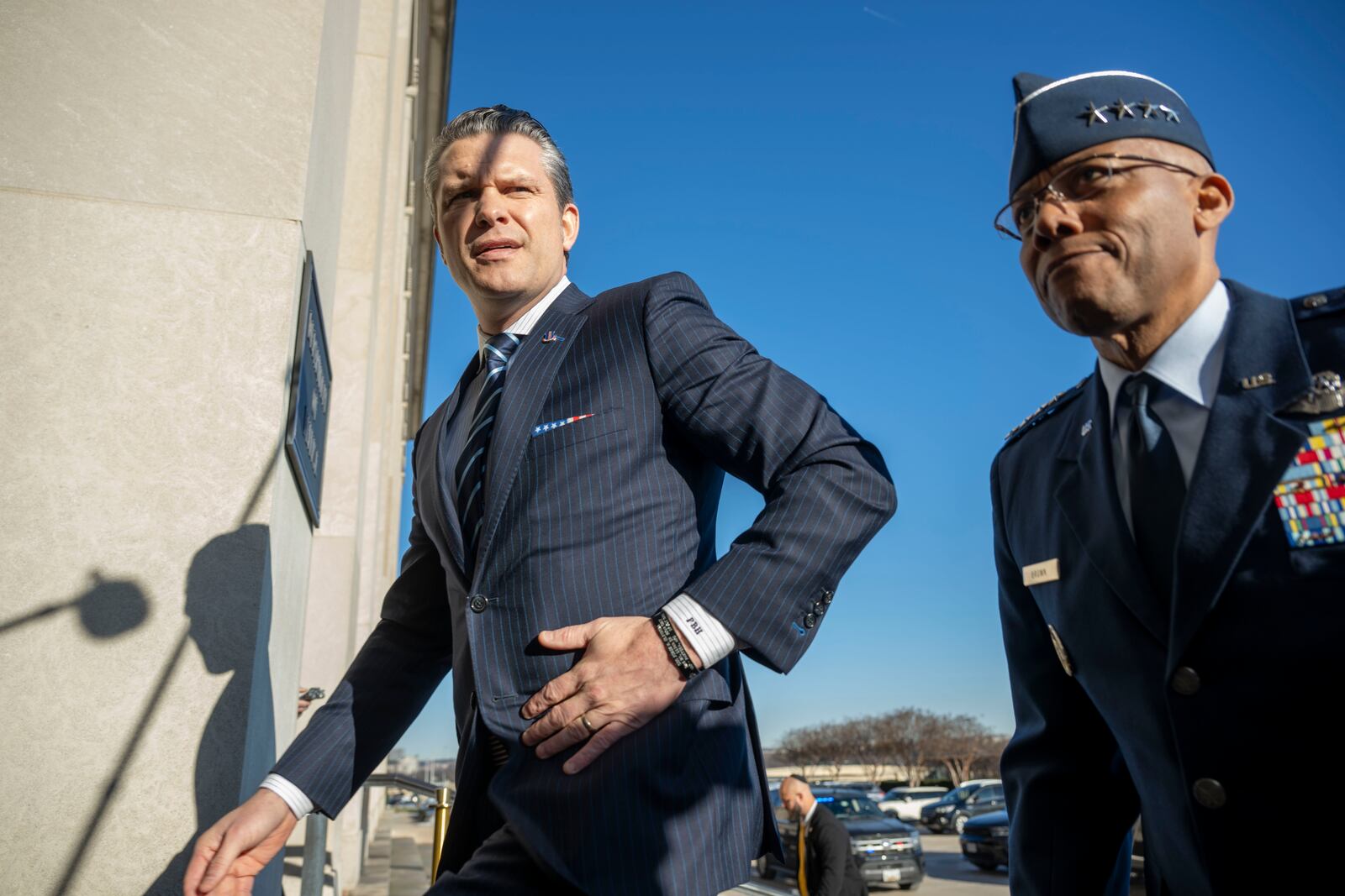 Defense Secretary Pete Hegseth walks into the Pentagon with Chairman of the Joint Chiefs of Staff Gen. Charles Q. Brown Jr., right, Monday, Jan. 27, 2025 in Washington. (AP Photo/Kevin Wolf)