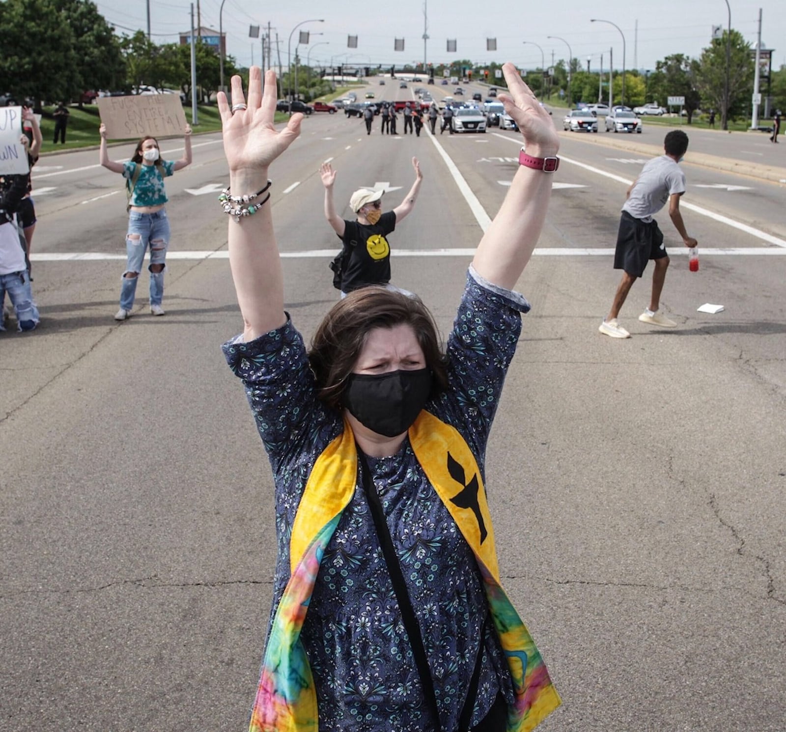 The Rev. Kellie C. Kelly of the Miami Valley Unitarian Universalist Fellowship raises her hands during a protest in Beavercreek on Monday. JIM NOELKER/STAFF