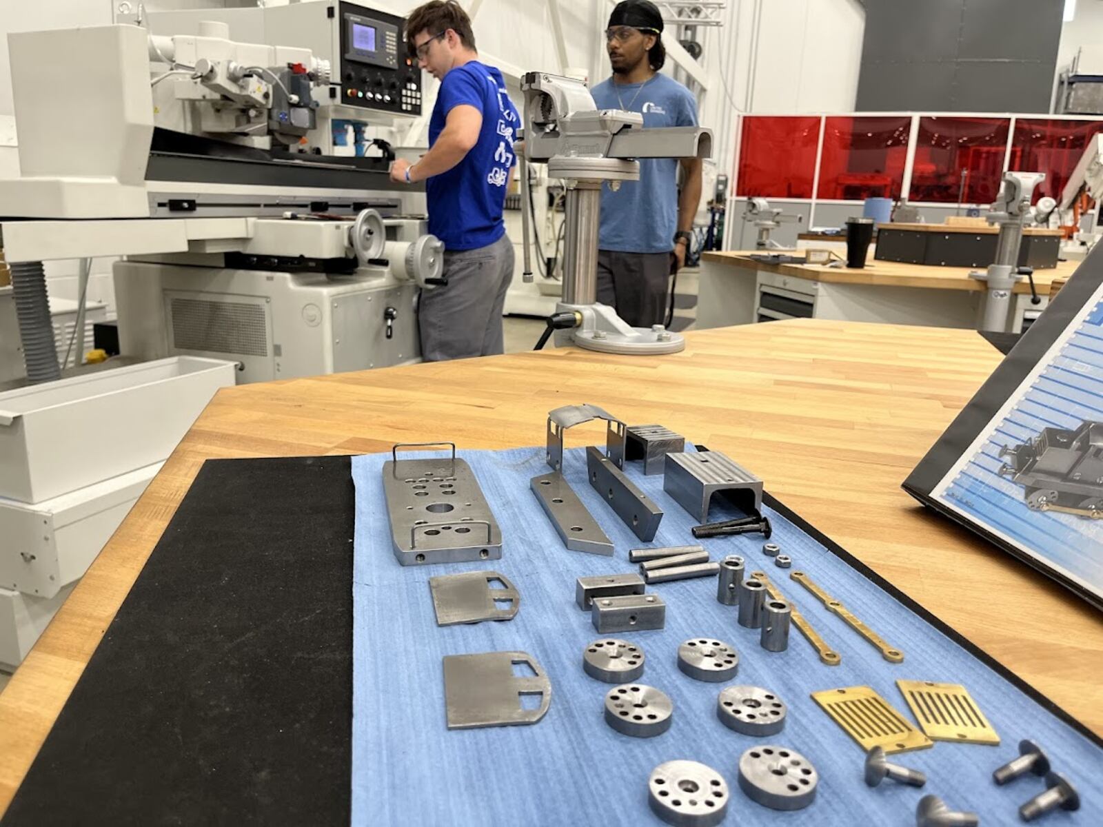 With examples of their metal pieces in the foreground, United Grinding apprentices Trent Saylor (left) and Lashawn Crockett were seen at work recently. The two are in the second year of a four-year United Grinding apprenticeship. THOMAS GNAU/STAFF