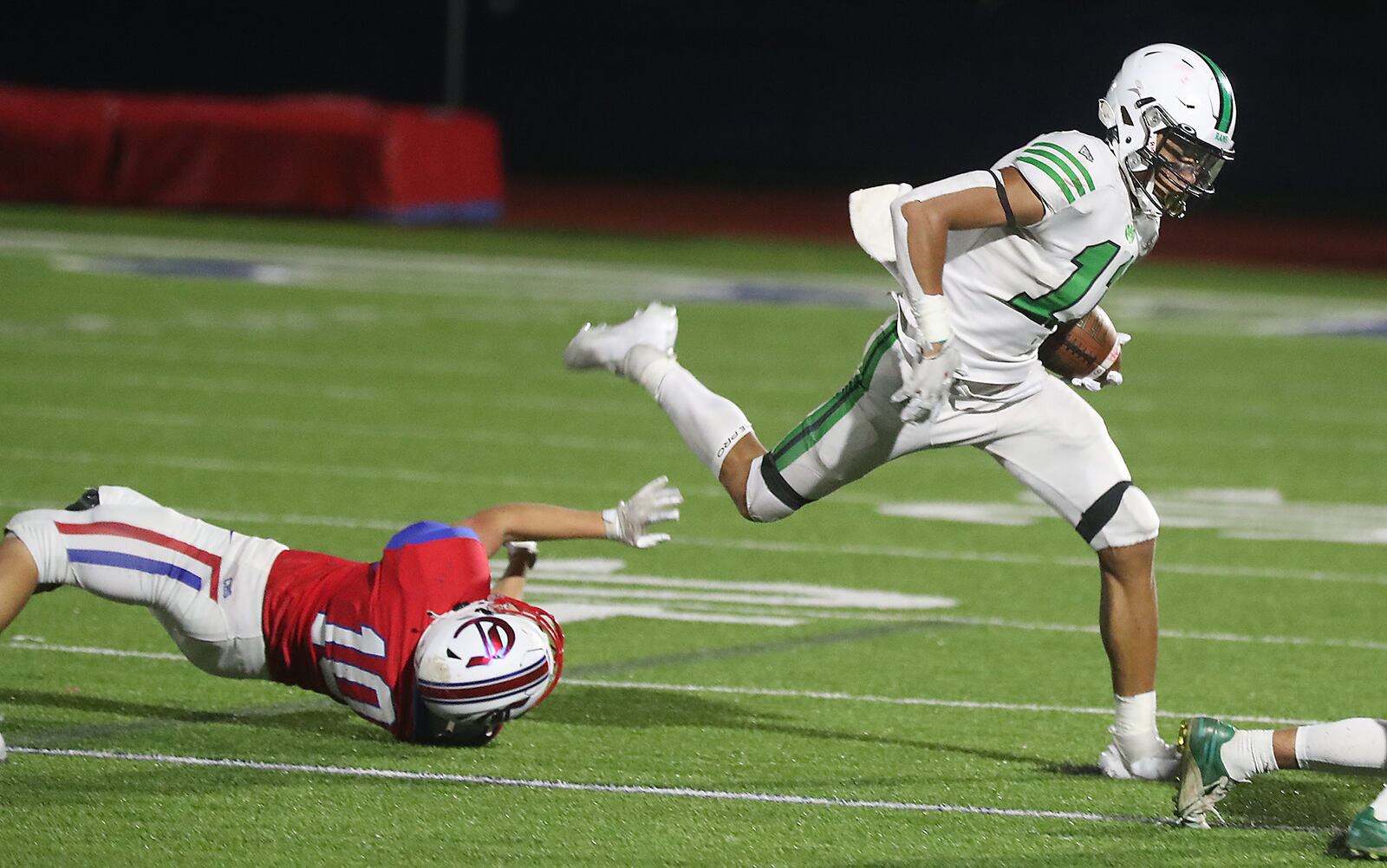 Badin's Braedyn Moore leaps out of a tackle by Carroll's Adam Franklin. BILL LACKEY/STAFF