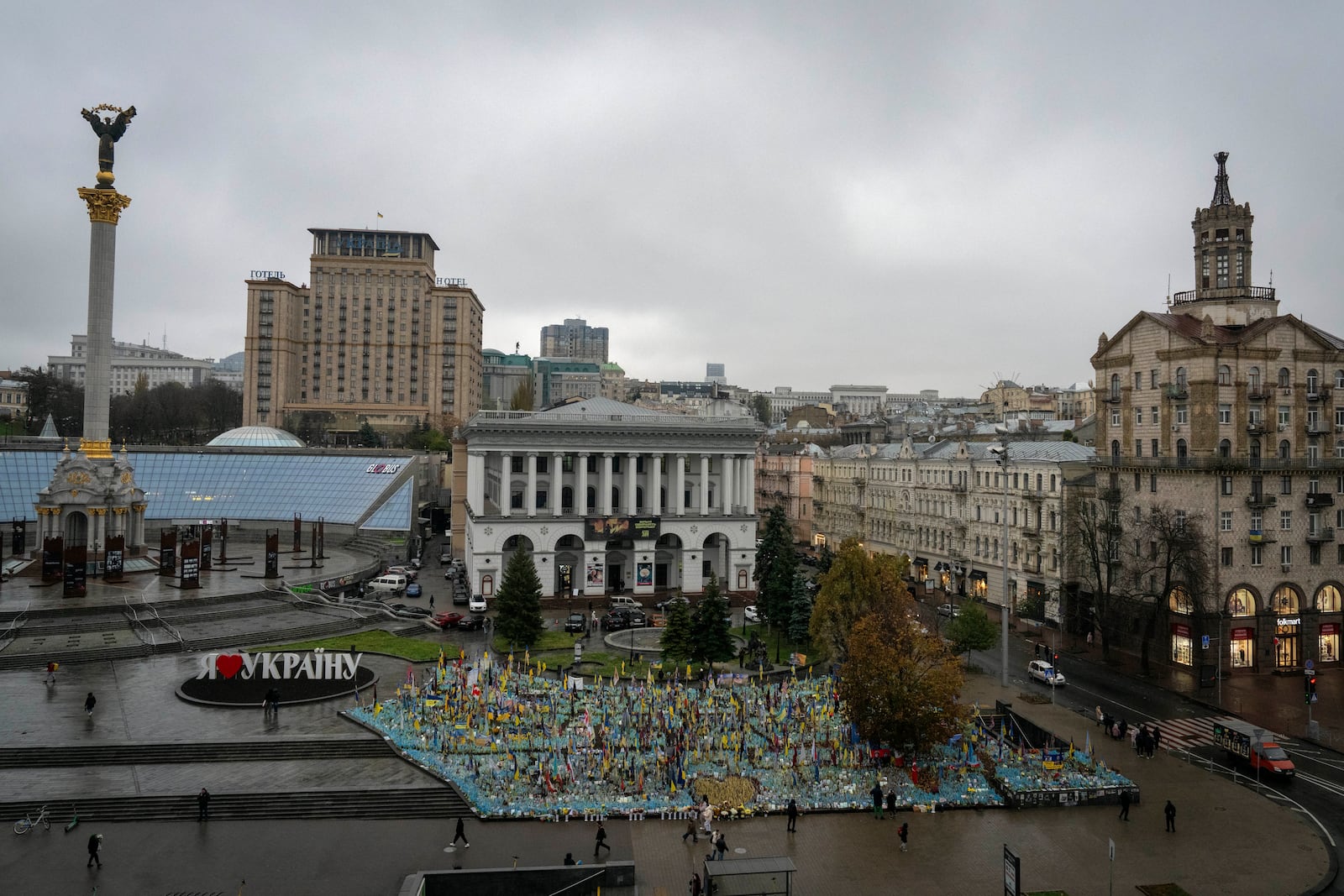 People walk past the memorial to fallen soldiers in Independence Square in Kyiv, Ukraine, Friday, Nov. 15, 2024. (AP Photo/Efrem Lukatsky)