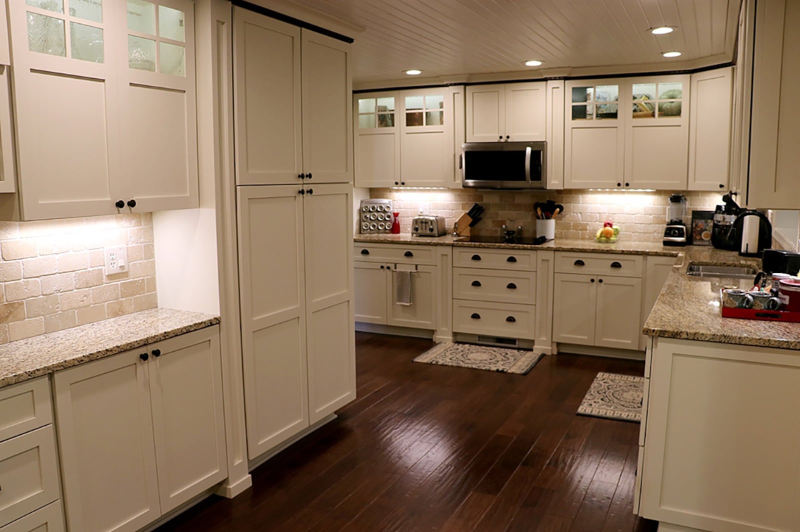 The kitchen is the centerpiece to the floor plan. Granite countertops complement the off-white cabinetry that includes a pantry. A double sink is below a pass-through window that looks into the family room. Along one wall of the breakfast room is a buffet counter with additional cabinetry and drawers. CONTRIBUTED PHOTO BY KATHY TYLER