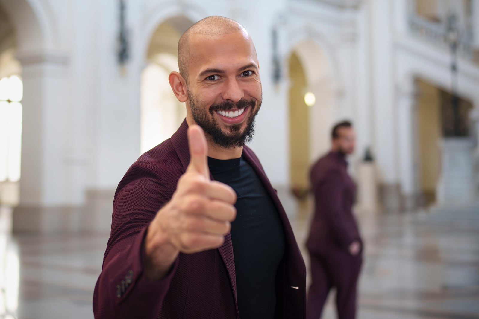 FILE - Andrew Tate poses giving a thumbs up upon arriving with his brother Tristan, right, at the Court of Appeals building in Bucharest, Romania, Tuesday, Oct. 15, 2024. (AP Photo/Vadim Ghirda, File)