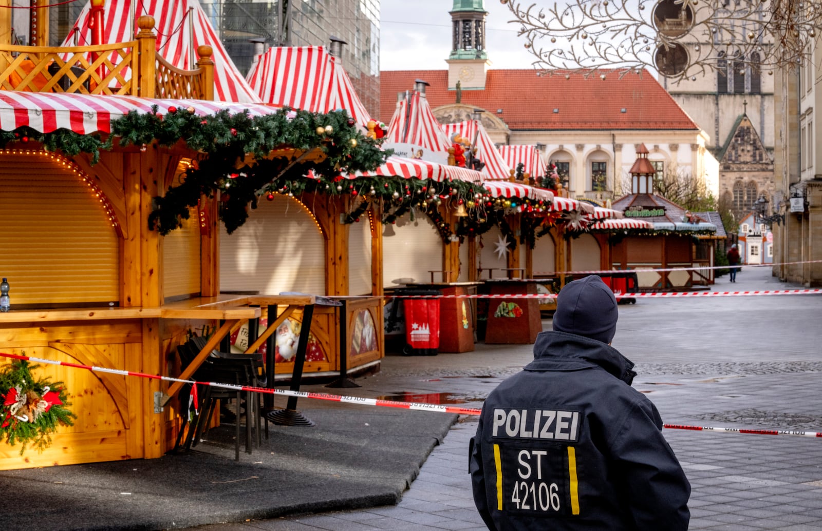 A police officer guards the Christmas Market, where a car drove into a crowd on Friday evening, in Magdeburg, Germany, on Sunday morning, Dec. 22, 2024. (AP Photo/Michael Probst)