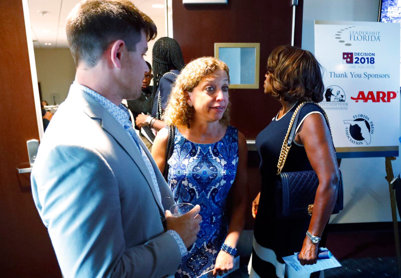 Congresswoman Debbie Wasserman Schultz, center, talks with people as she attends a debate between Florida gubernatorial candidates, Republican Ron DeSantis and Democrat Andrew Gillum, Wednesday, Oct. 24, 2018, at Broward College in Davie, Fla. (AP Photo/Wilfredo Lee)