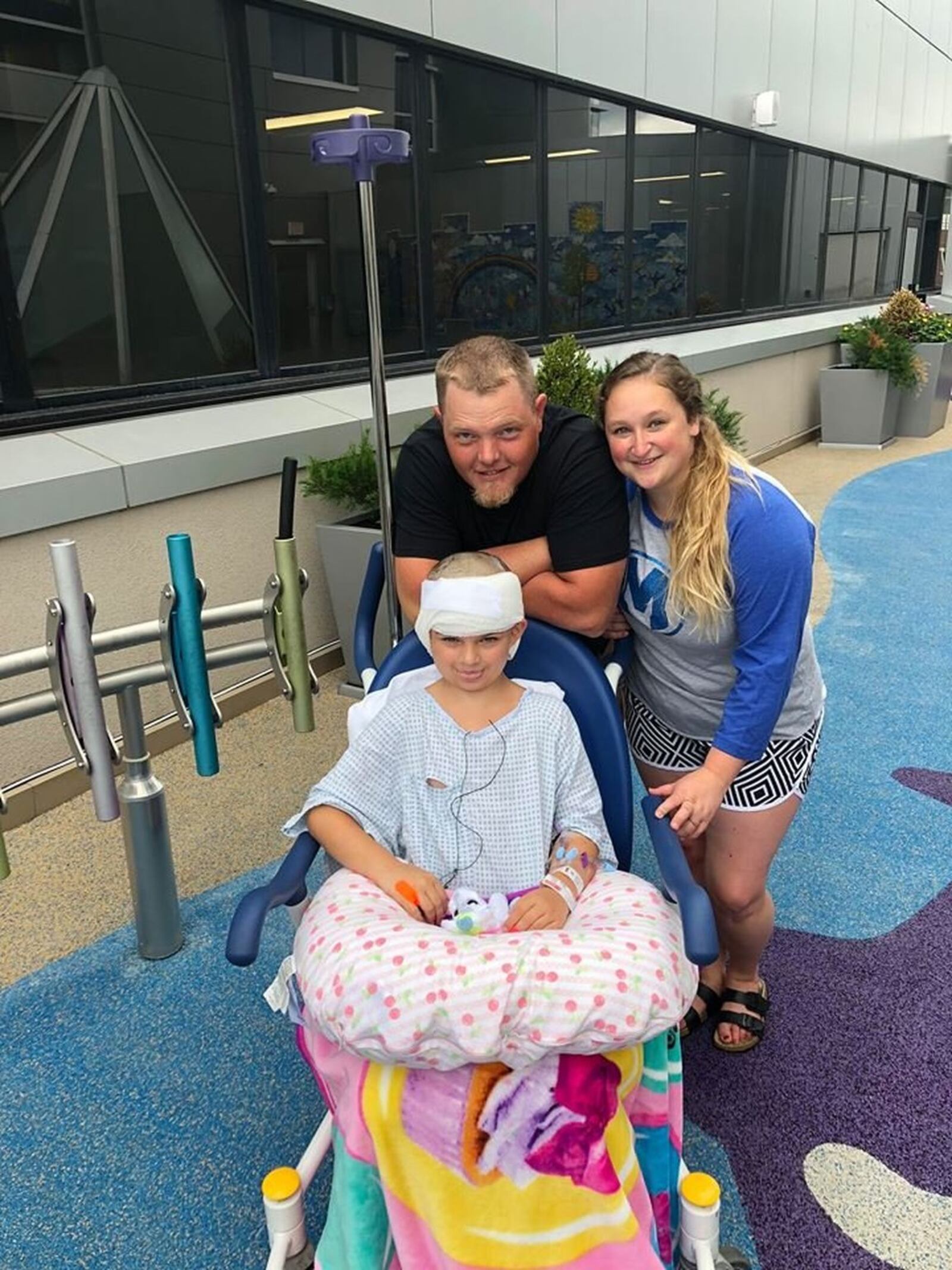 Savannah Coleman, the 8-year-old girl who was viciously attacked by a pit bull in July. She is pictured with her mother, Tierney Dumont and her boyfriend, Nate Baker.