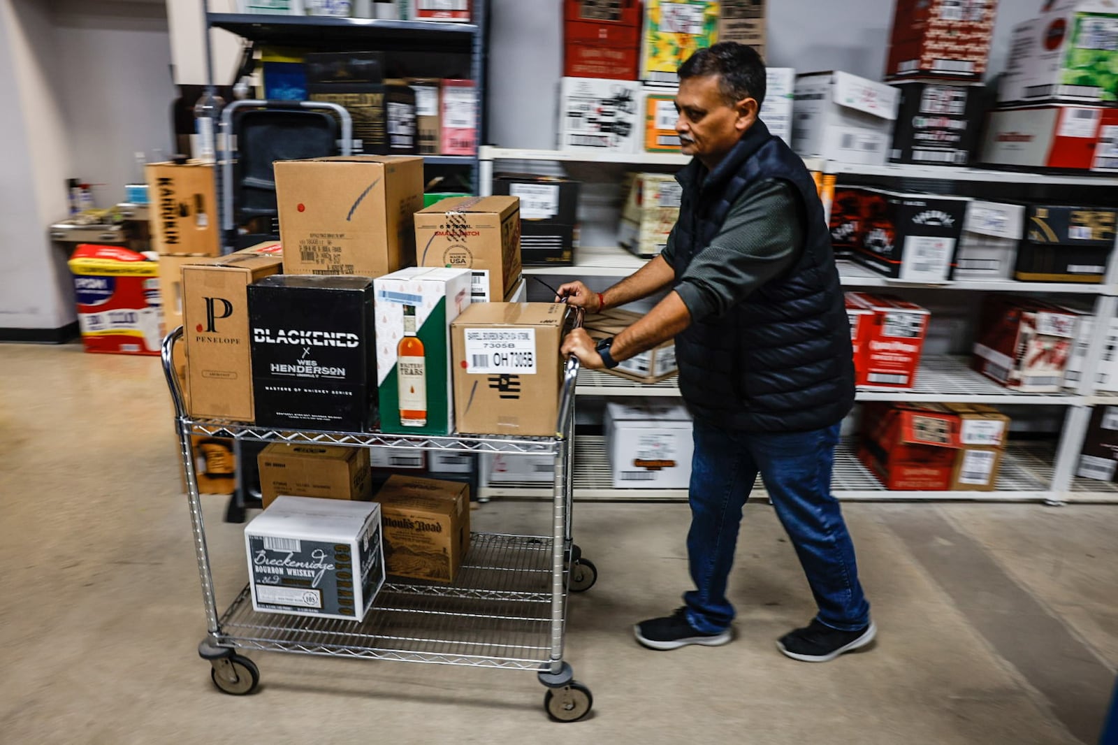 Jay Patel, co-owner of Centerville Liquor & Wine on South Main Street in Centerville, moves around boxes of liquor for retail at the store on Friday, Feb. 24, 2023. Total sales of liquor increased in Ohio in 2022 by nearly 1%, while the amount of gallons sold decreased by nearly 1.8%. JIM NOELKER/STAFF