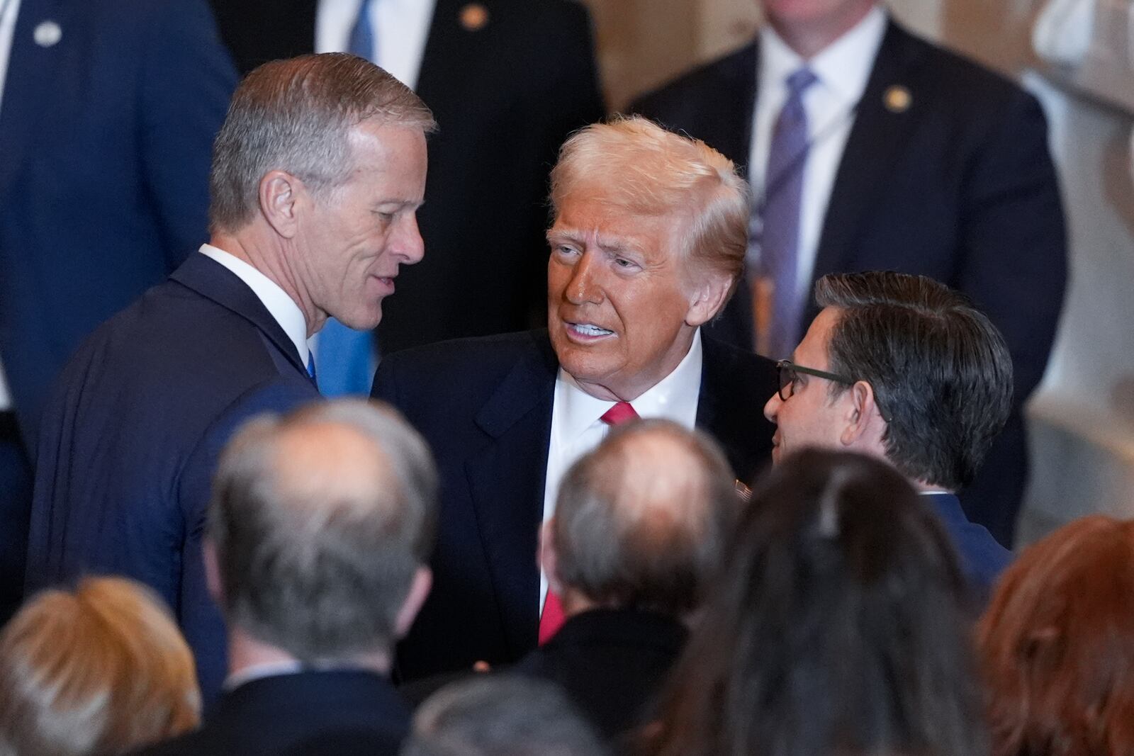 President Donald Trump talks to Senate Majority Leader John Thune, R-S.D., left and and House Speaker Mike Johnson, R-La., right, after he spoke to the National Prayer Breakfast, at the Capitol in Washington, Thursday, Feb. 6, 2025. (AP Photo/J. Scott Applewhite)