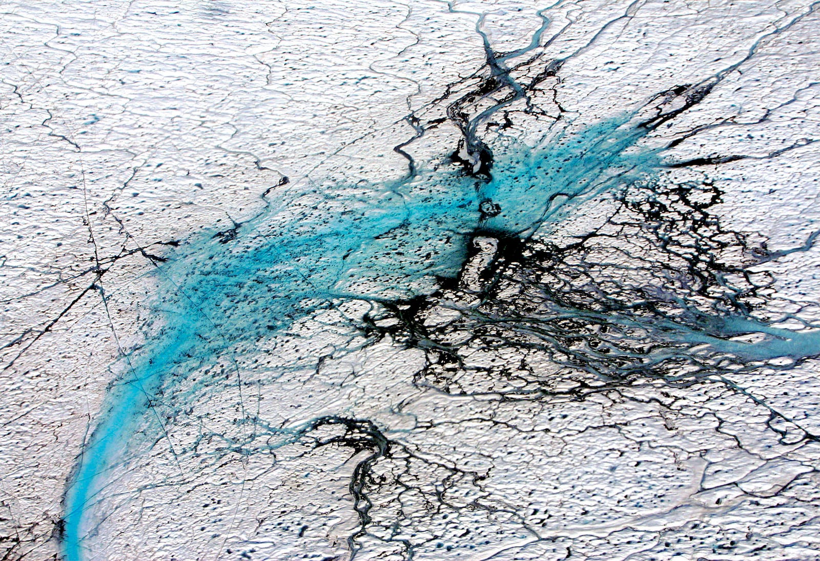 FILE - Varying shades of blue rivers meander through the Greenland ice cap in this aerial photograph from August 2005. (AP Photo/John McConnico, file)