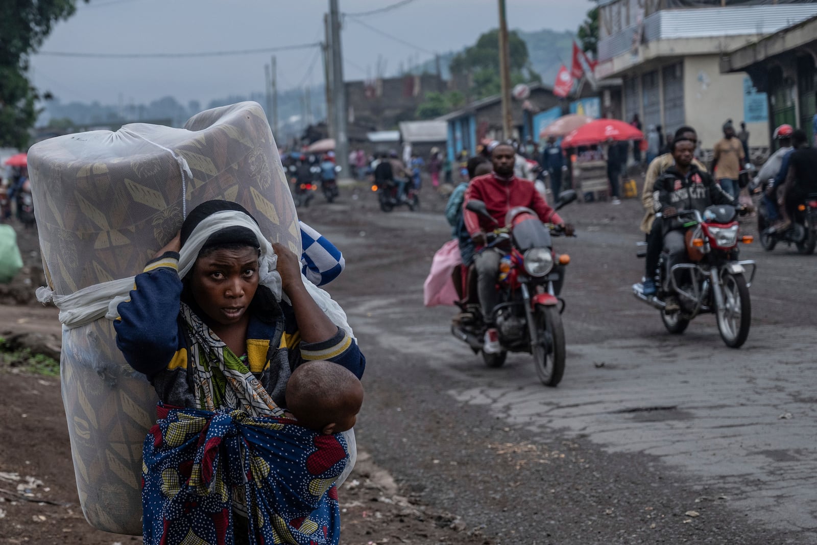 People displaced by the fighting with M23 rebels make their way to the center of Goma, Democratic Republic of the Congo, Sunday, Jan. 26, 2025. (AP Photo/Moses Sawasawa)