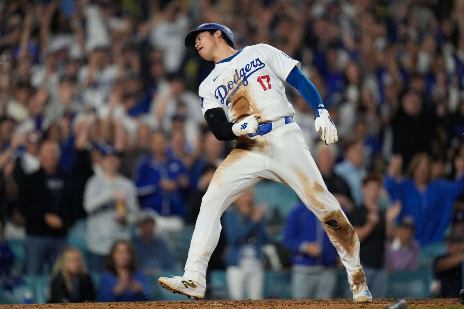 Los Angeles Dodgers' Shohei Ohtani celebrates after scoring on a single by Freddie Freeman against the New York Mets during the fourth inning in Game 1 of a baseball NL Championship Series, Sunday, Oct. 13, 2024, in Los Angeles. (AP Photo/Gregory Bull)